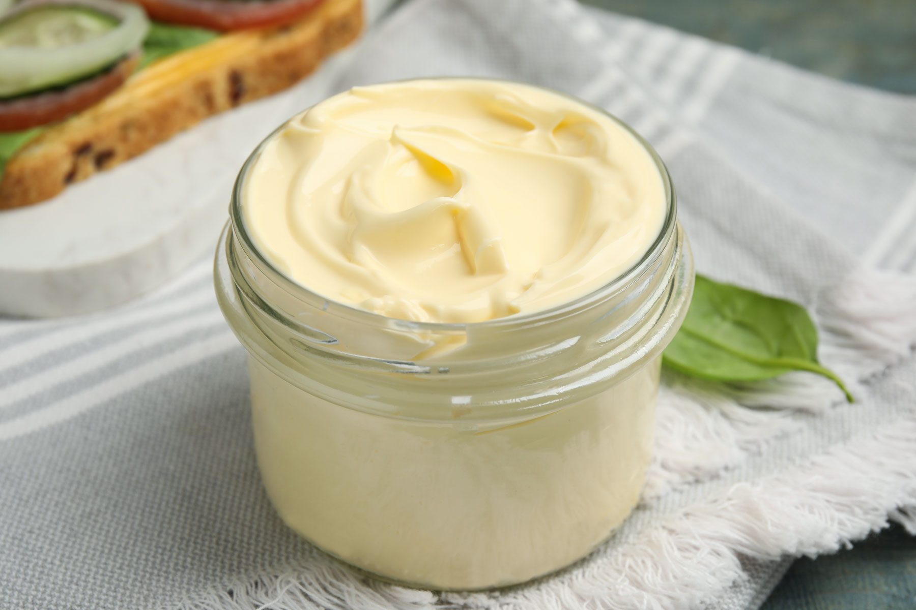 ar of delicious mayonnaise and napkin on light blue wooden table