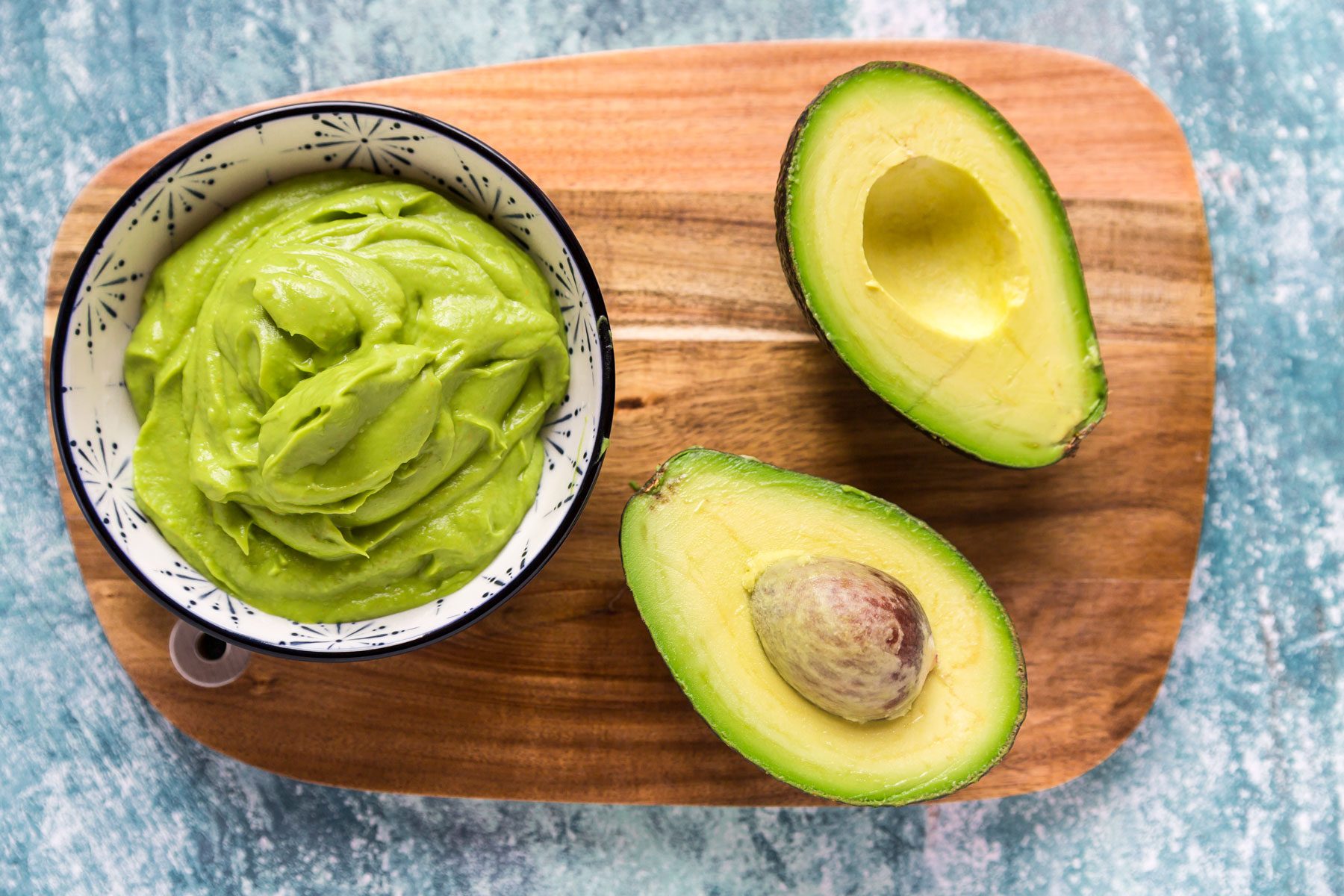 Bowl of Avocado puree and sliced avocado