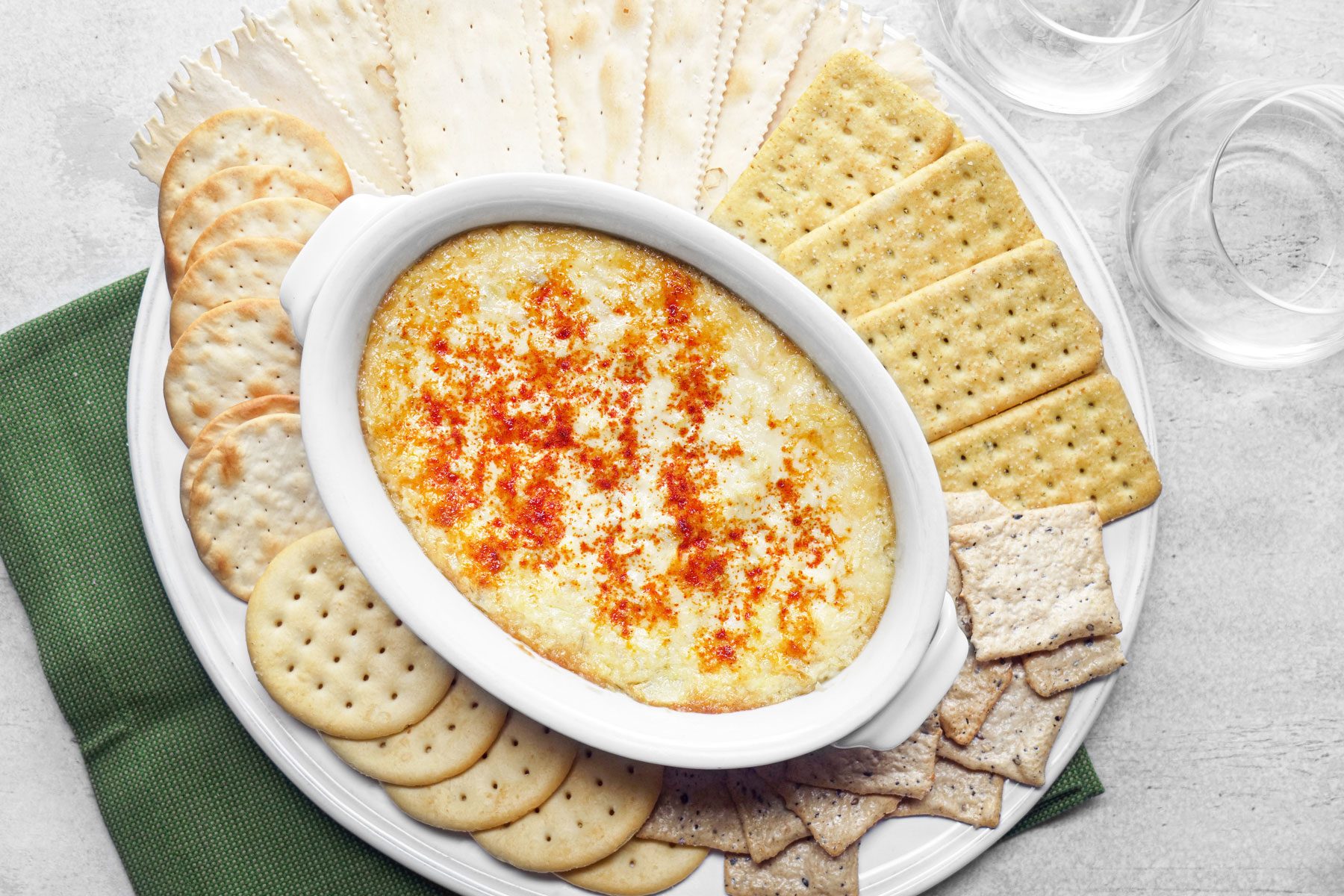 Artichoke Dip served with crackers in a large white plate