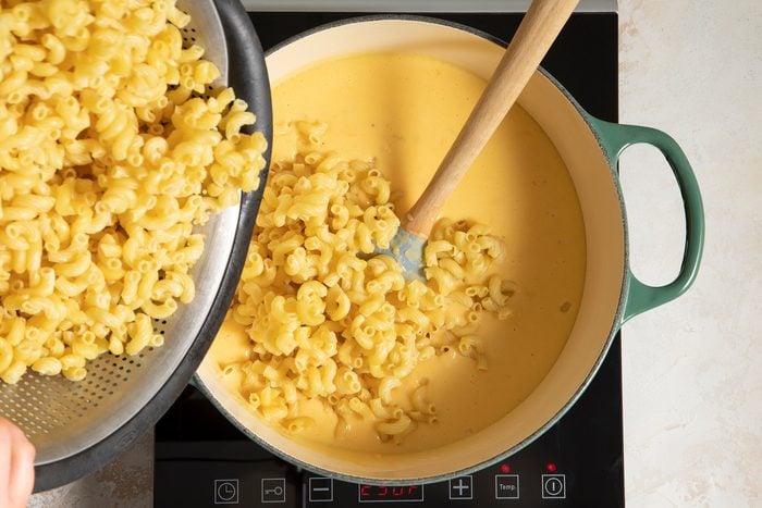 Adding macaroni in dutch oven for Baked Mac and cheese recipe
