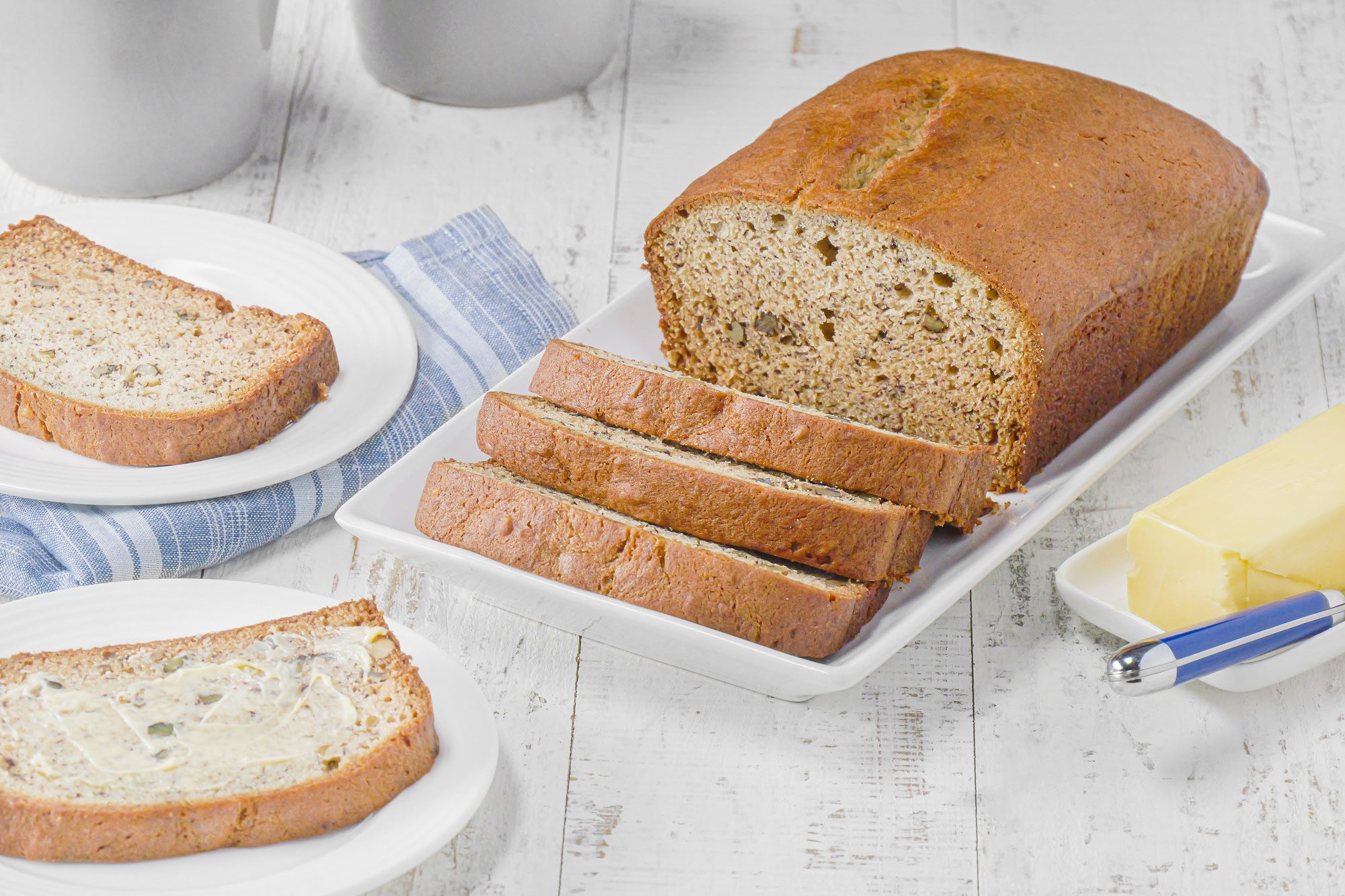 Banana Walnut Bread in a small ceramic tray on white painted wooden surface