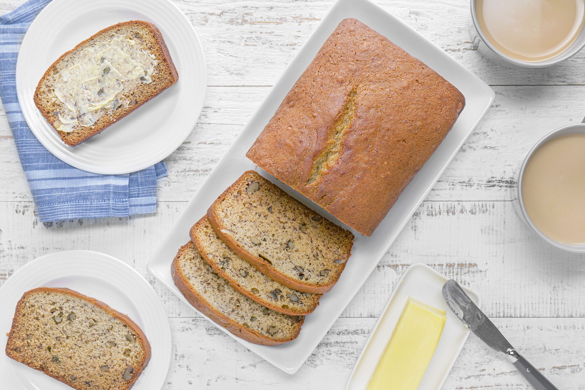 Banana Walnut Bread in a small ceramic tray on white painted wooden surface