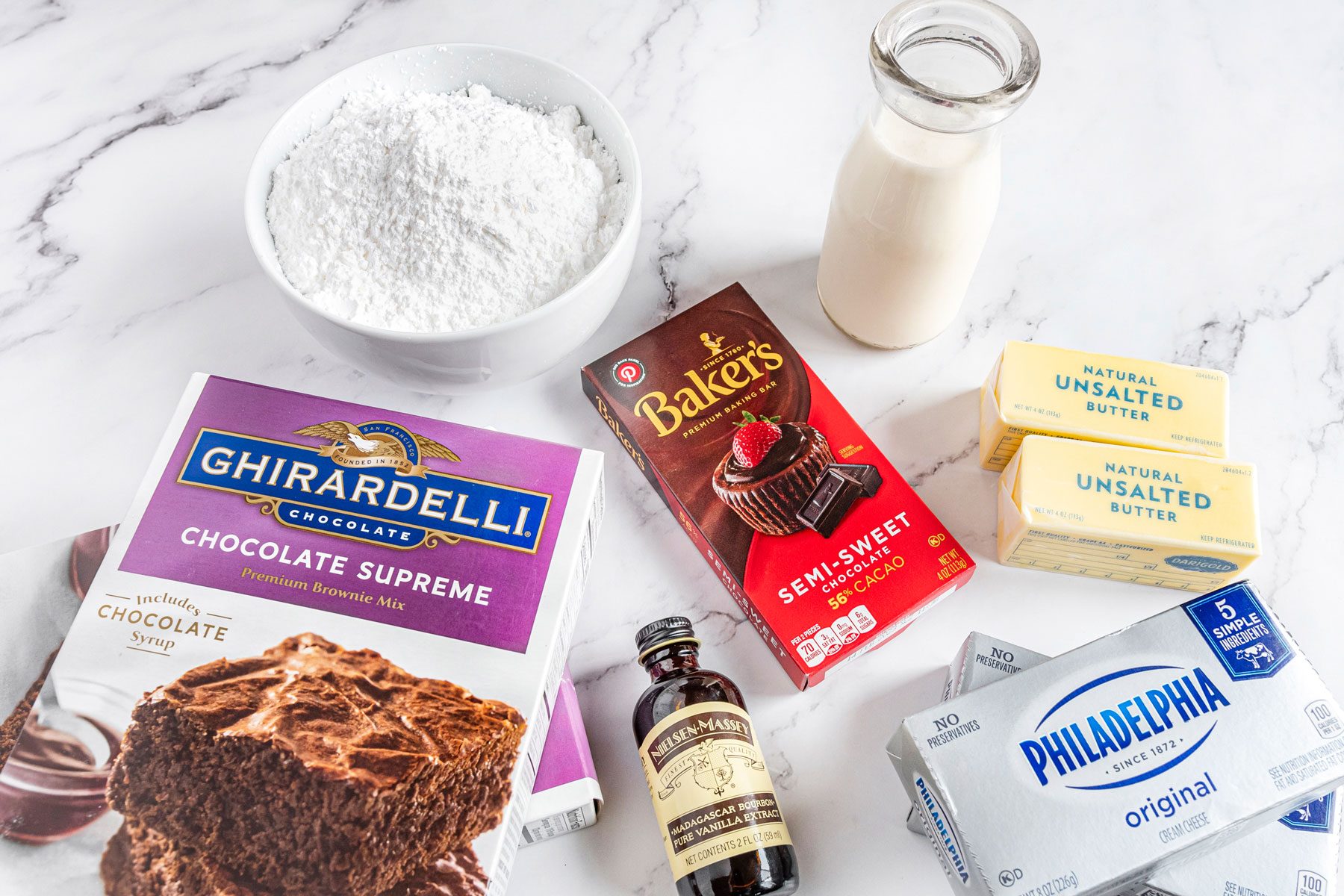 Brownie box, cream and other ingredients on the marble countertop 