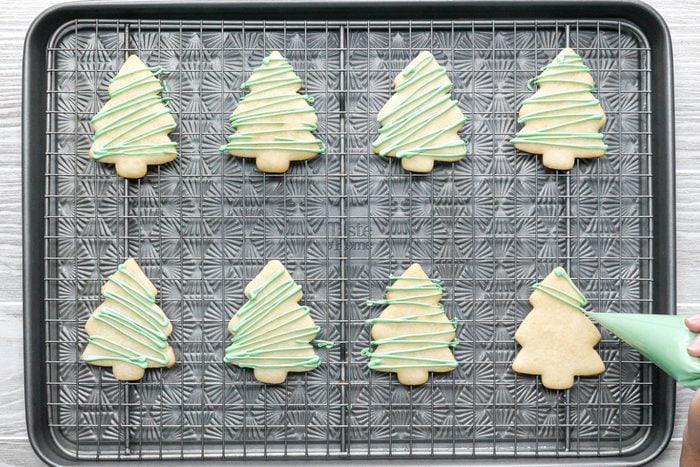 Decorating Christmas Sugar Cookies with food coloring on a cooling tray