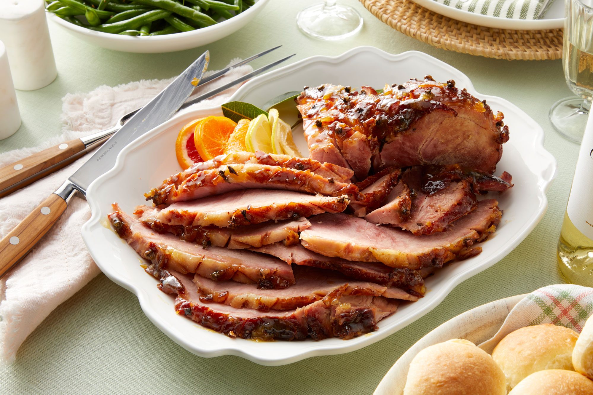A table set with a plate of Easter ham and a glass of wine