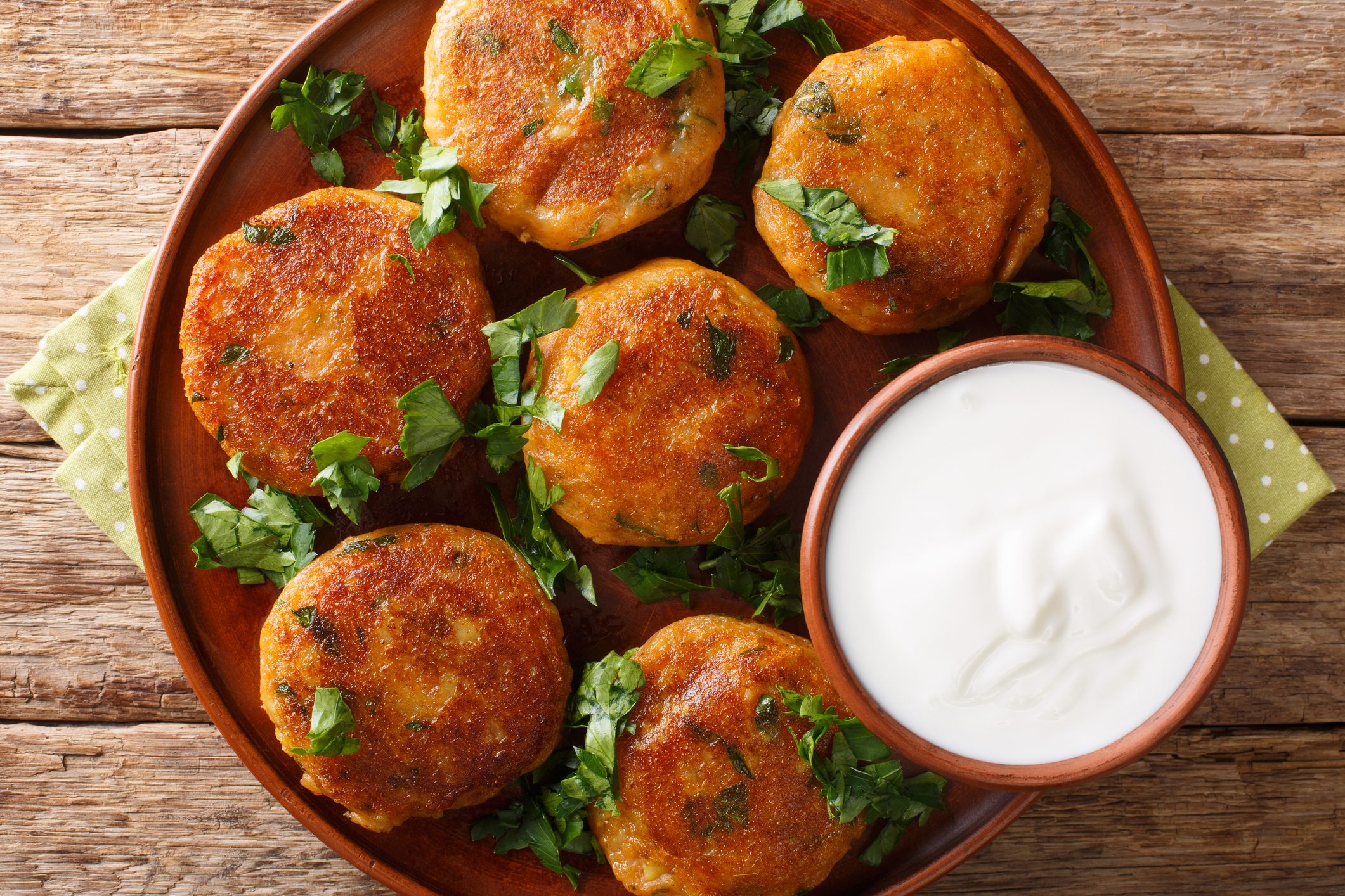 Tasty Aloo Tikki is a popular Indian street food which is basically crispy and spicy potato patty with yogurt close-up on the table. Horizontal top view