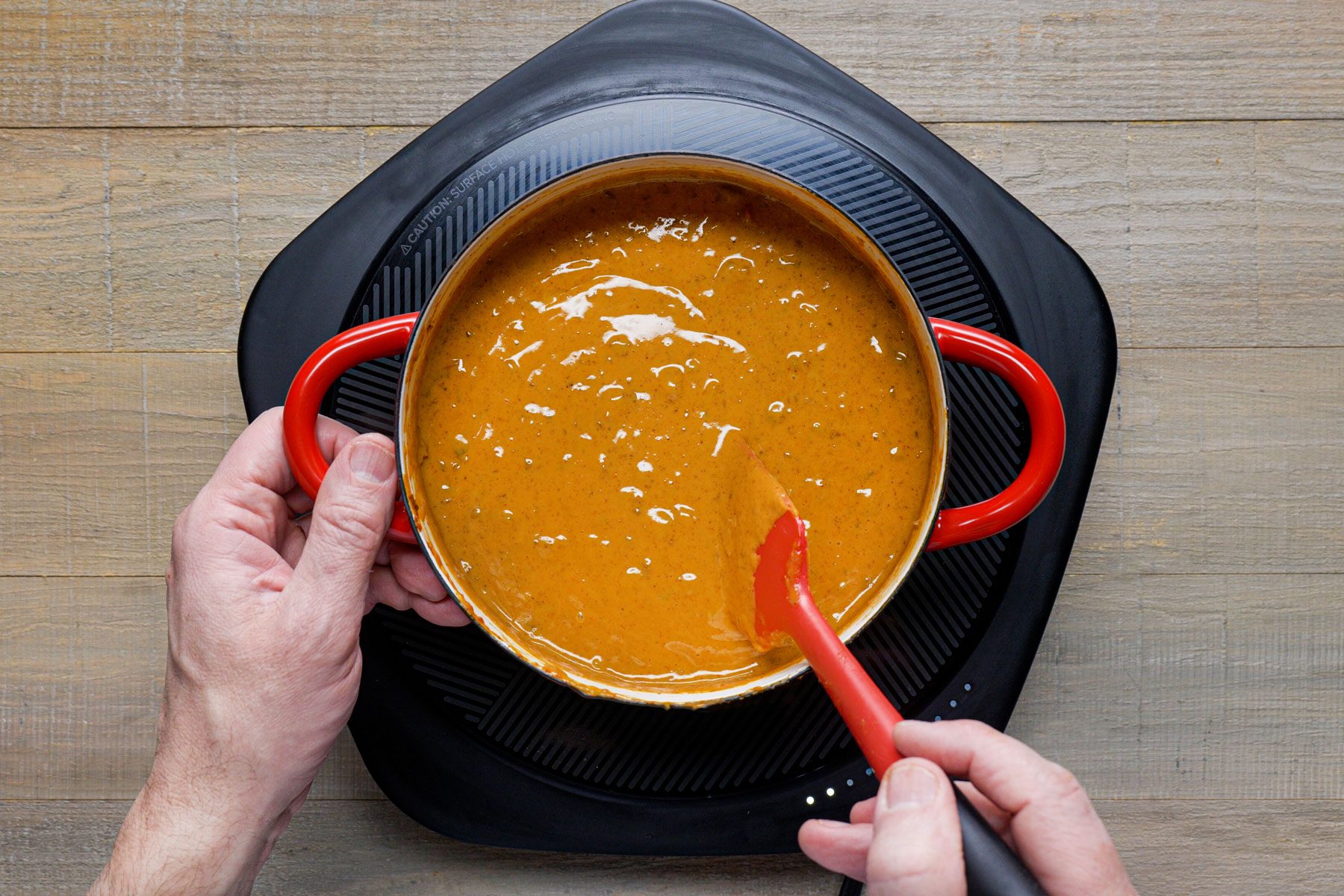 using a spatula to mix the ingredients in a saucepan