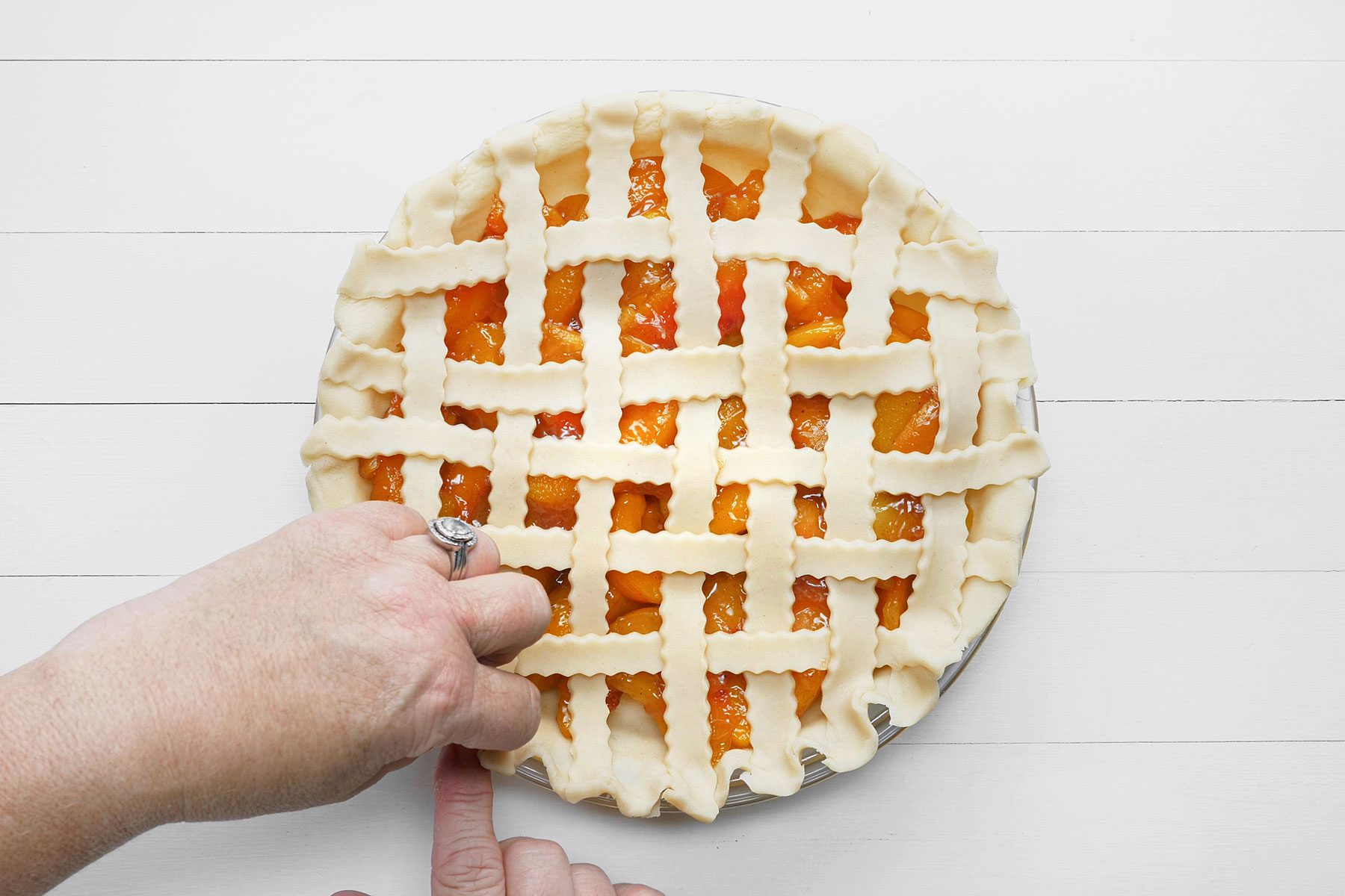 Fluting the edges of the dough strips set on pie