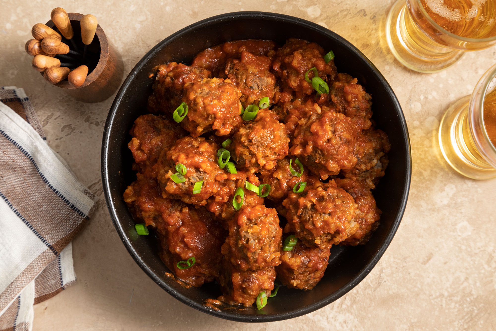 A bowl of Porcupine Meatballs with savory sauce and beer