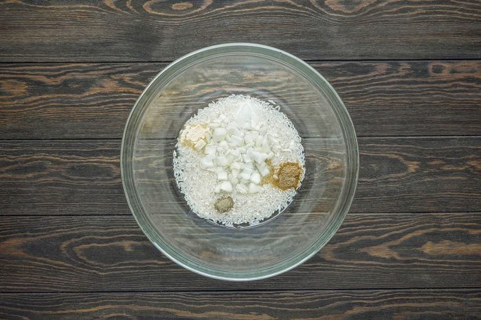 Combine the uncooked rice, water, chopped onion, salt, celery salt, pepper and garlic powder in a large bowl