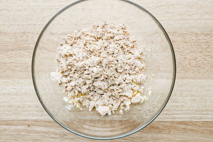 minced salmon in a glass bowl on a wooden surface