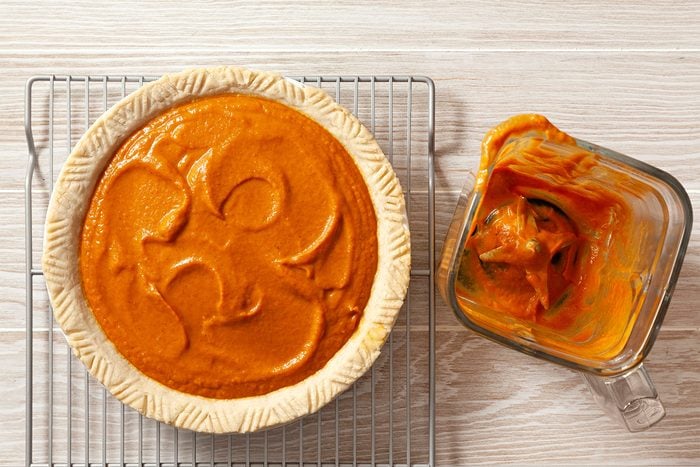 overhead shot; wooden background; poured filling into pie from blender; pie crust over wired rack;