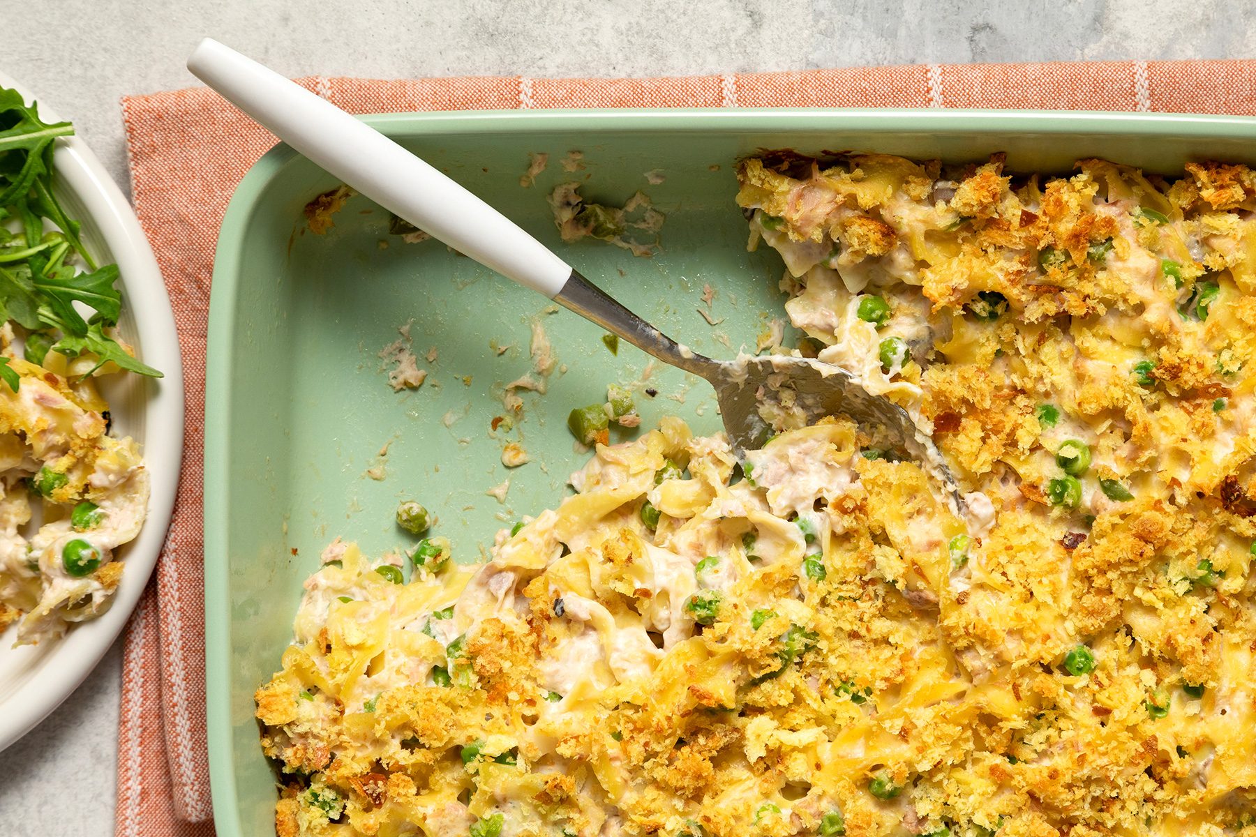 A green dish of creamy tuna noodle casserole
