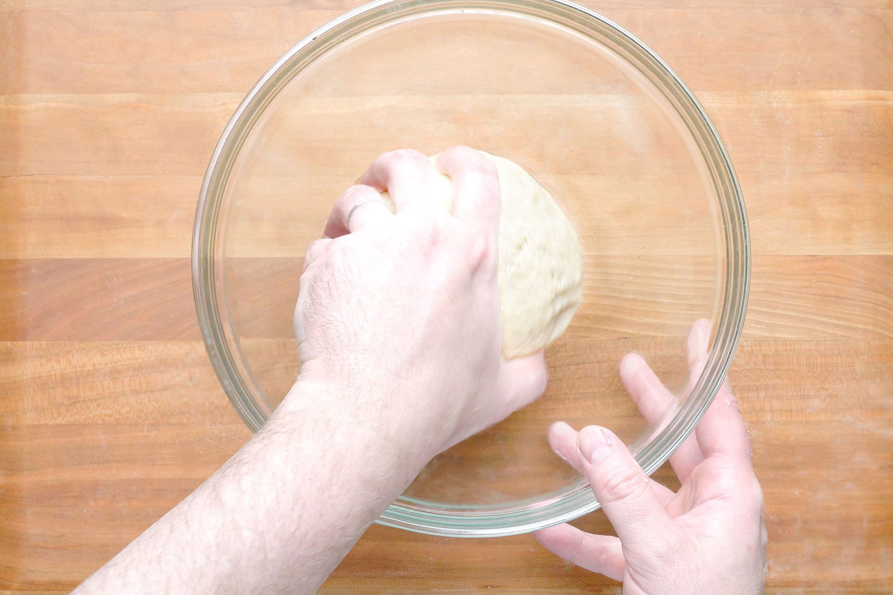 Putting dough in a glass bowl to rest
