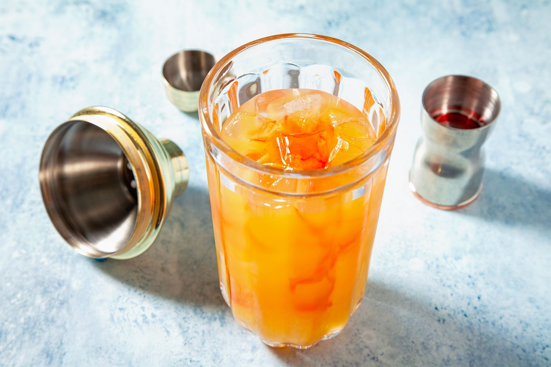 high angle shot of sweet rum punch in a shaker with ice