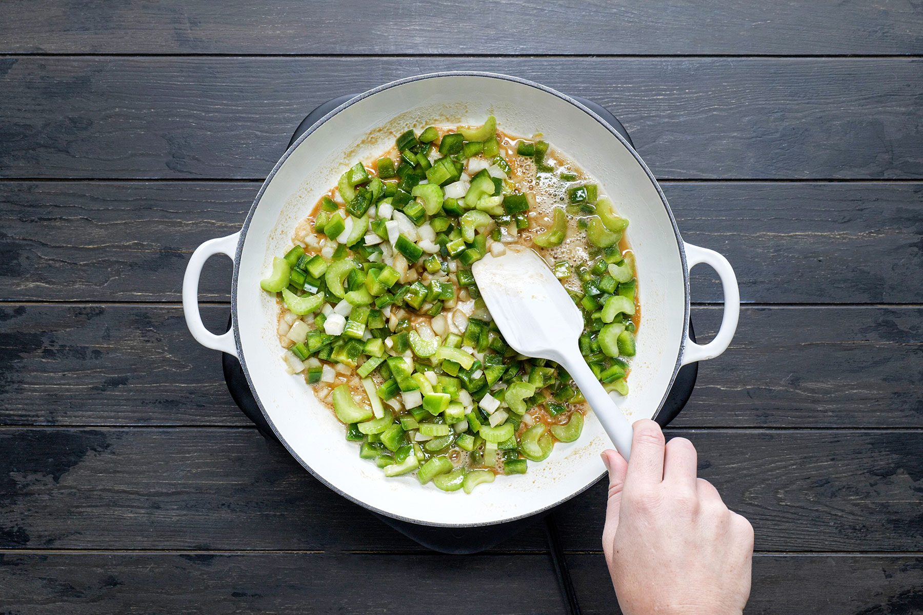 Mixing cajun holy trinity in skillet