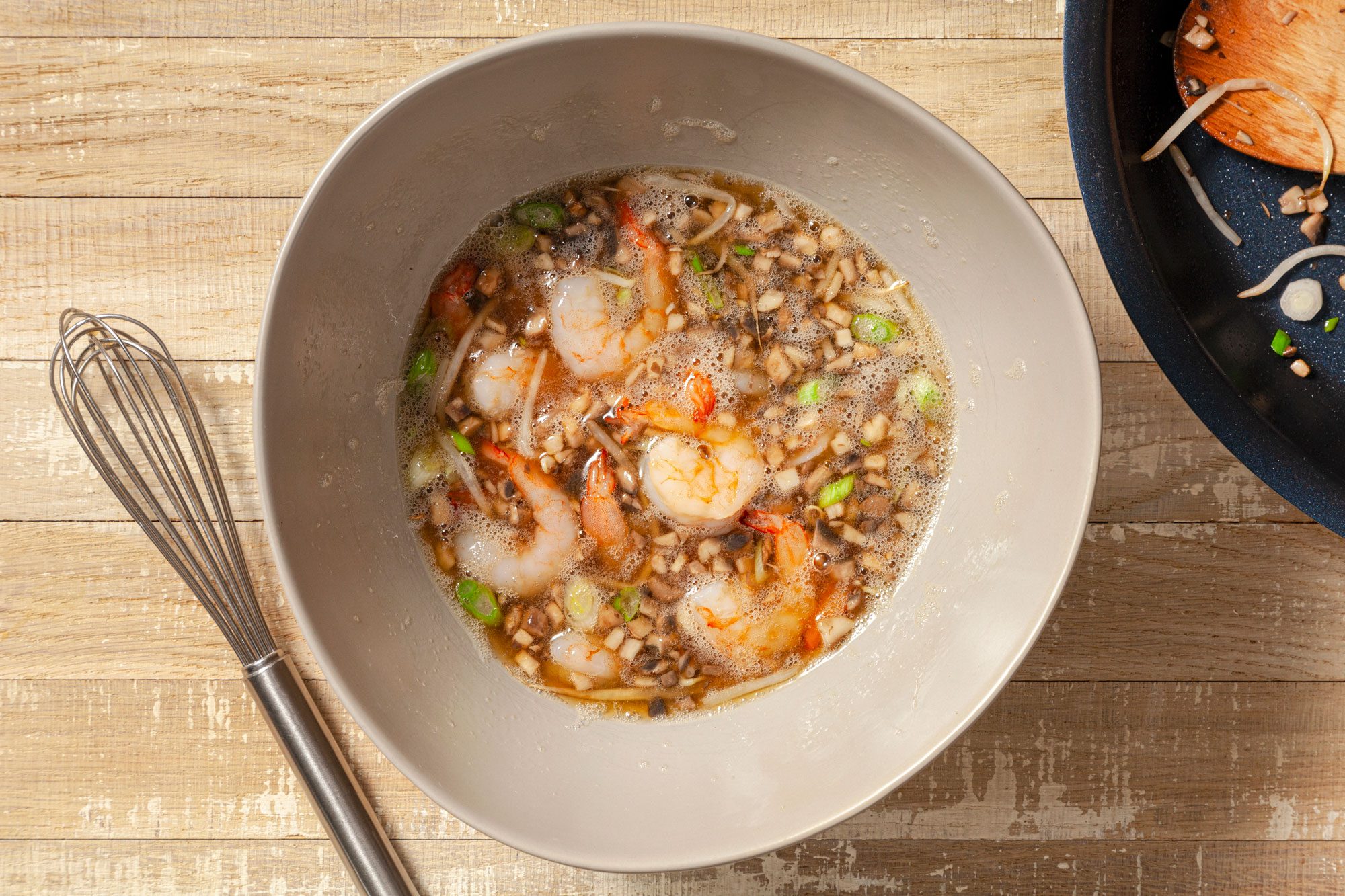 Sauteed Shrimps, Bean Sprouts, Onions, Eggs and Soy Sauce in a large bowl on Wooden Surface
