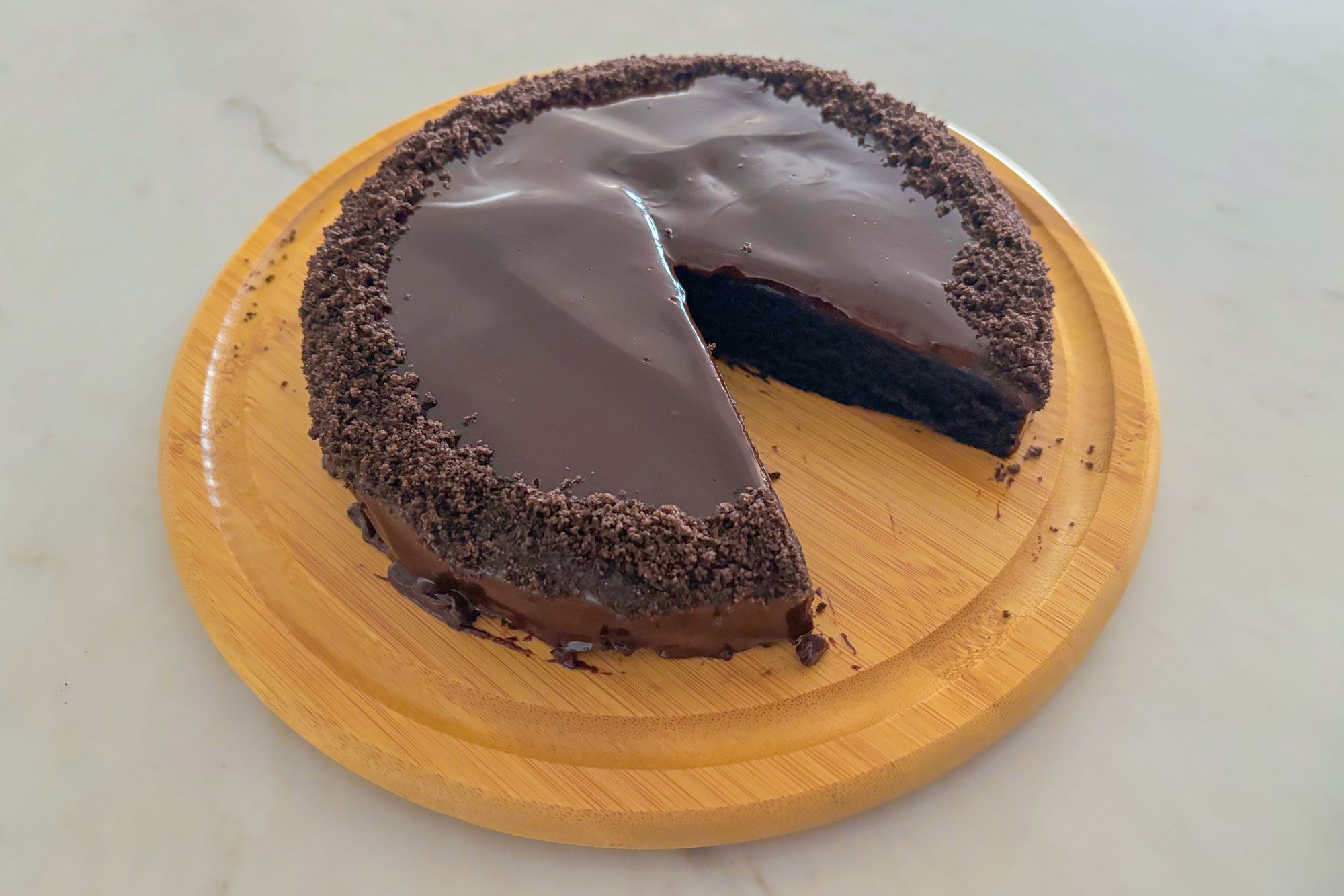Sliced Oreo Cake on a serving plate garnished with crushed Oreo's on the side