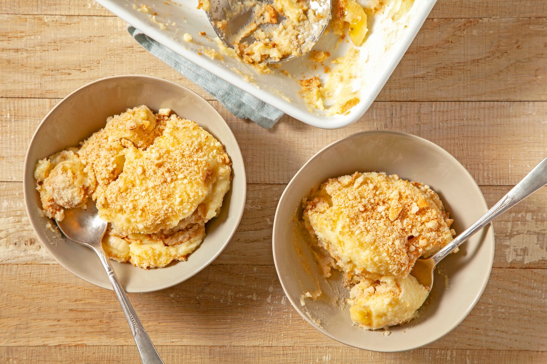 Two bowls of banana pudding on a wooden table