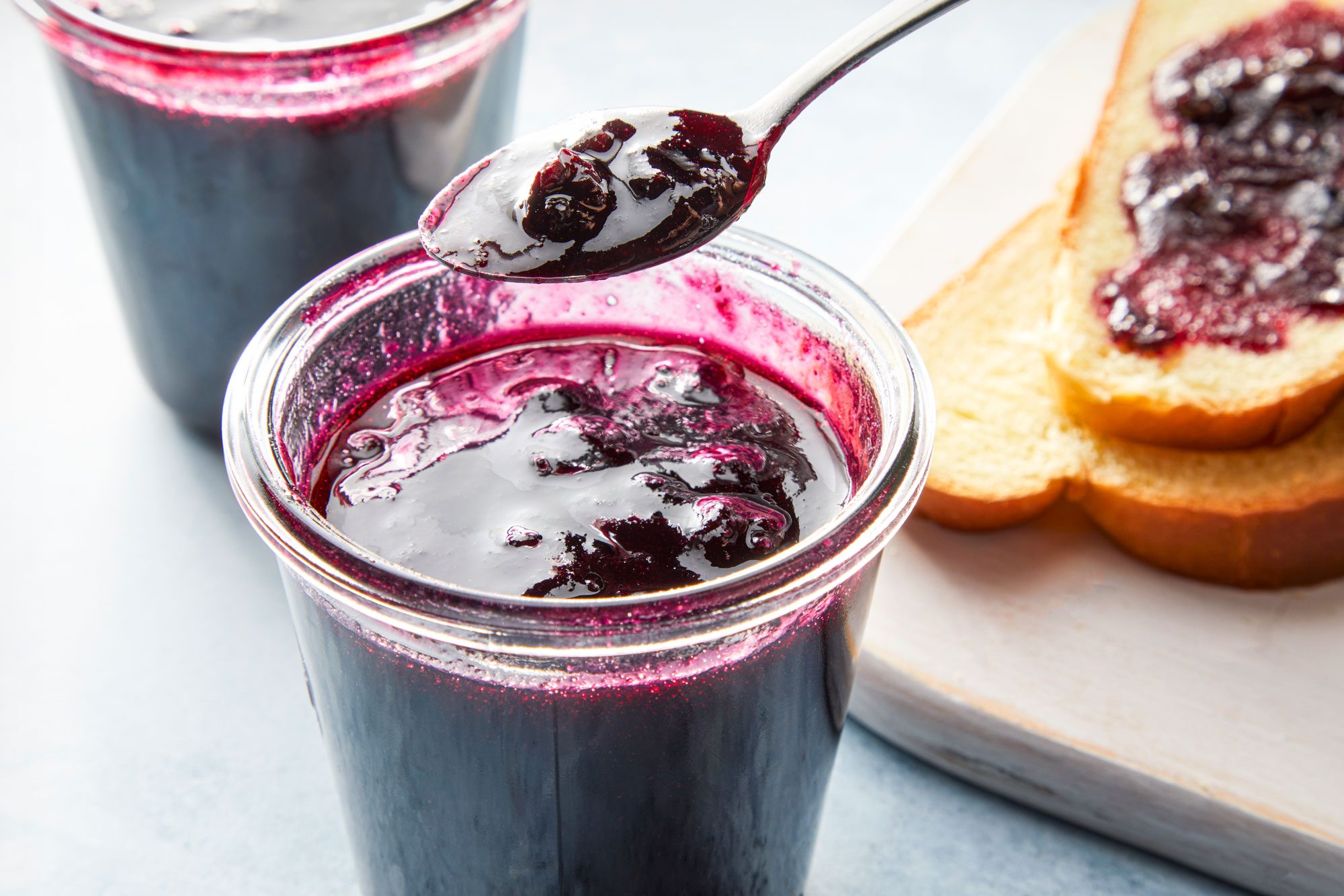 High angle view shot of Luscious Blueberry Jam; spread on breads; store in glass jars; blue texture background;