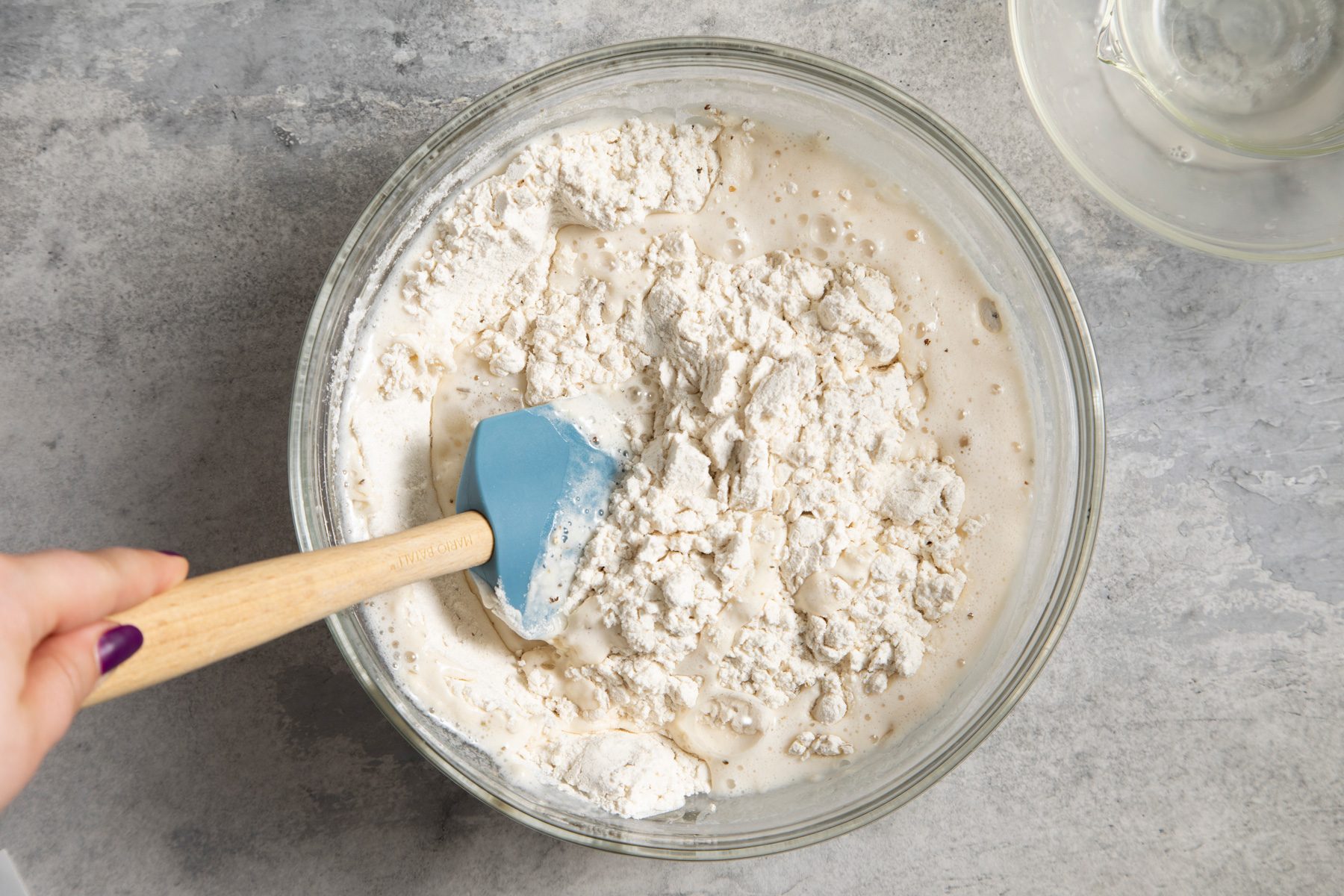 A bowl of flour with a spatula