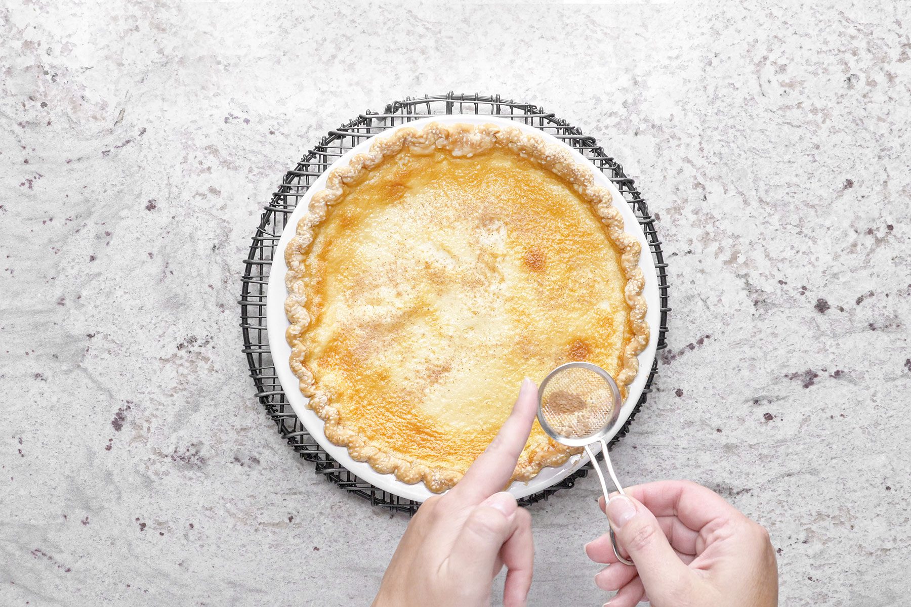 Sprinkling nutmeg over baked custard