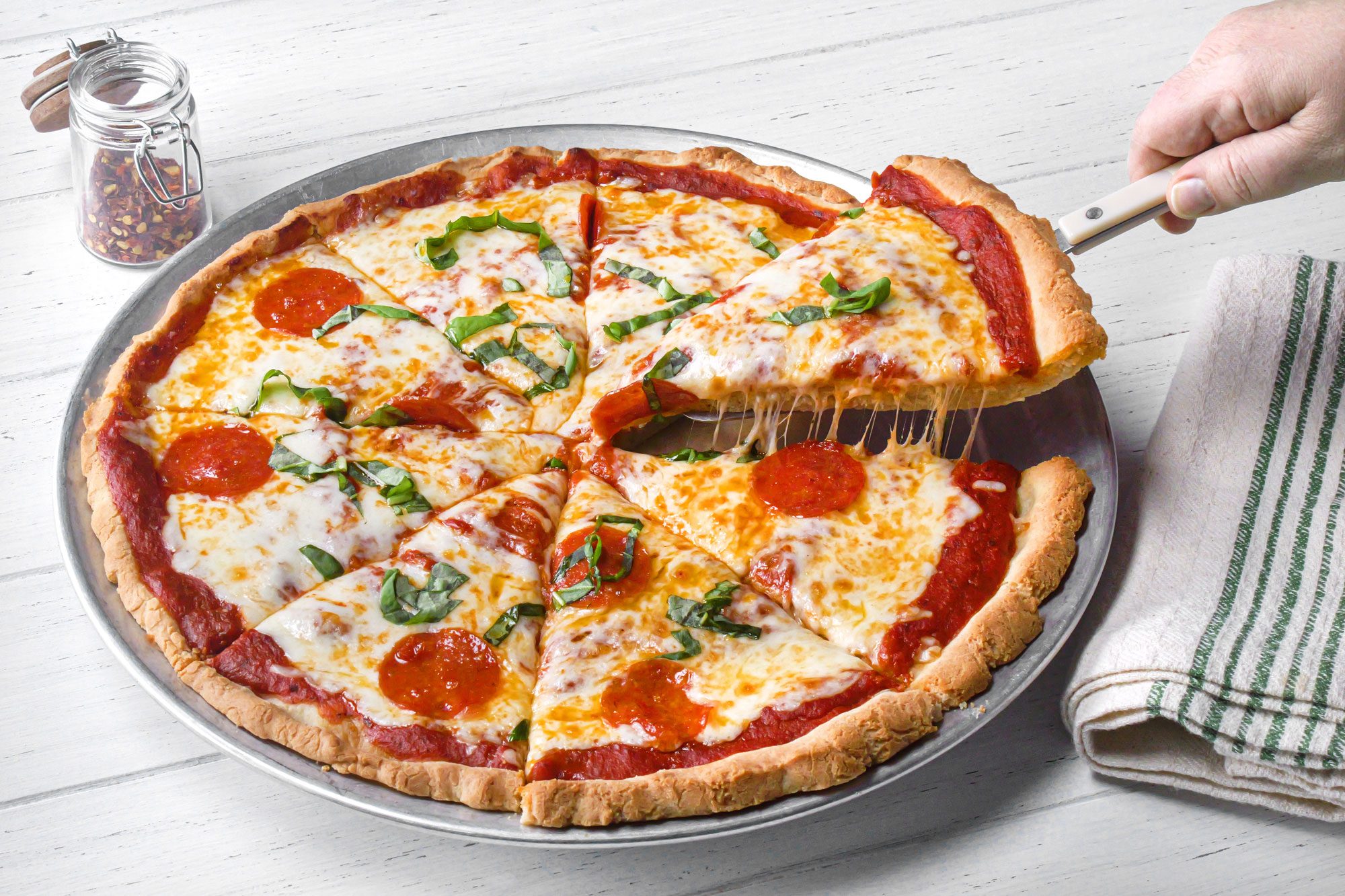 Gluten Free Pizza on a plate on white painted wooden surface