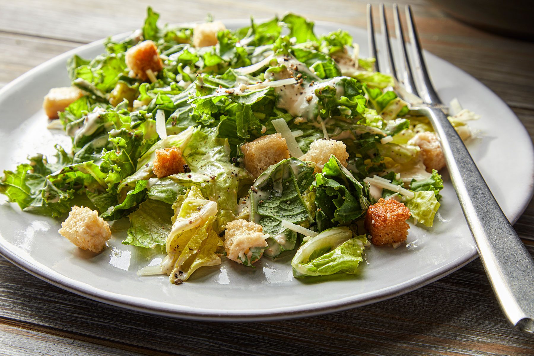 Kale Caesar Salad served on white plate with fork