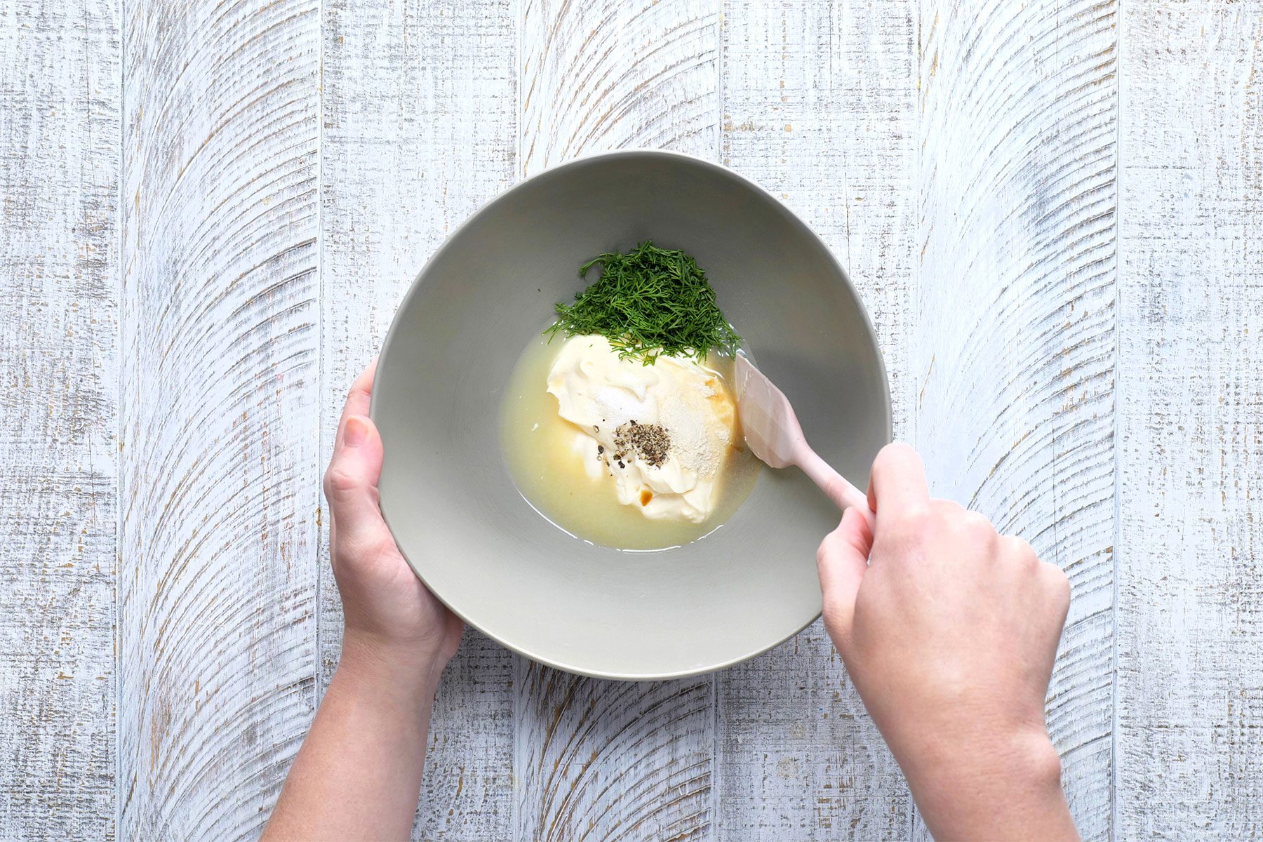 overhead shot of mayonnaise, lemon juice, dill in a large bowl