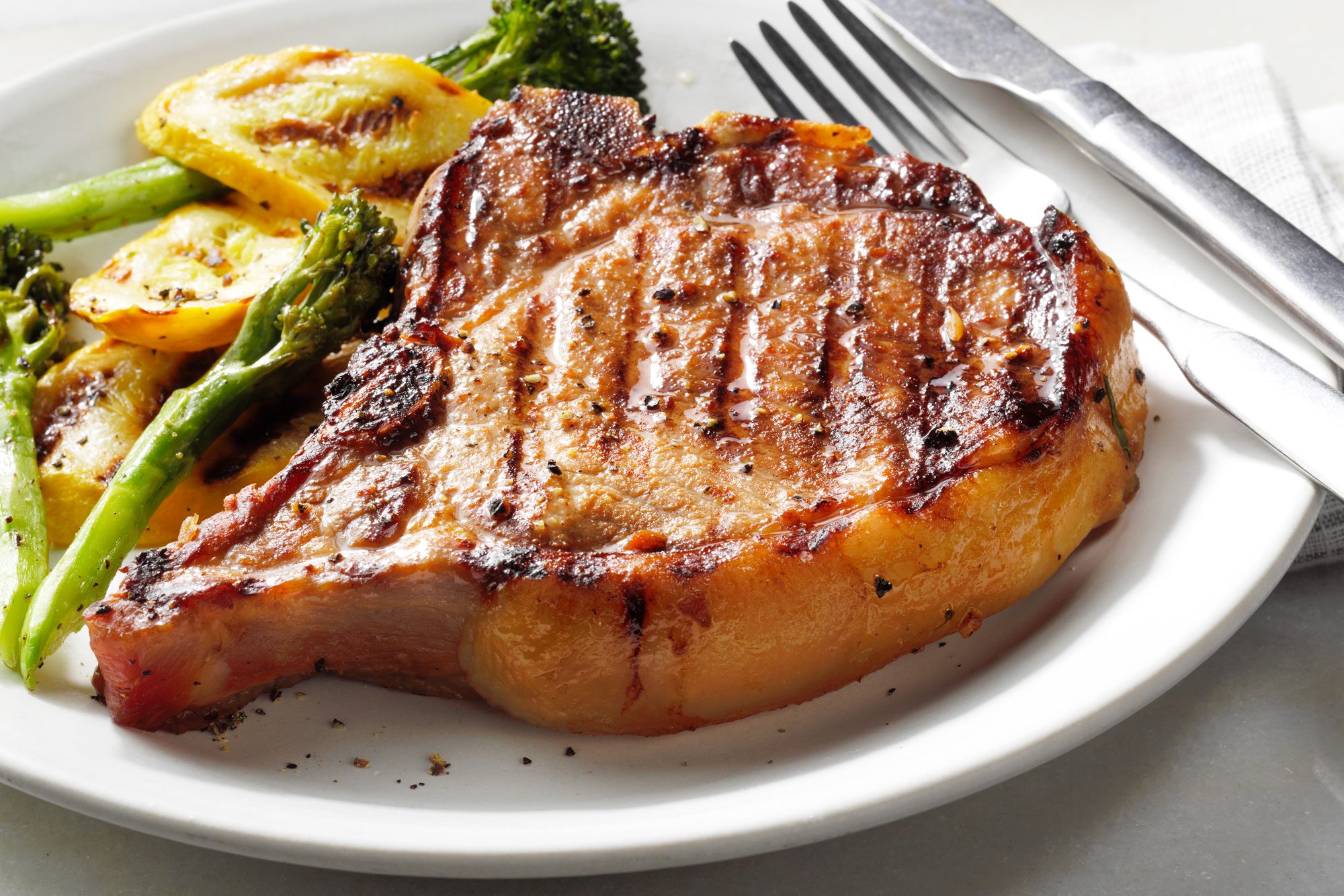 Simple Pork Chop Marinade served on a plate with fork and knife
