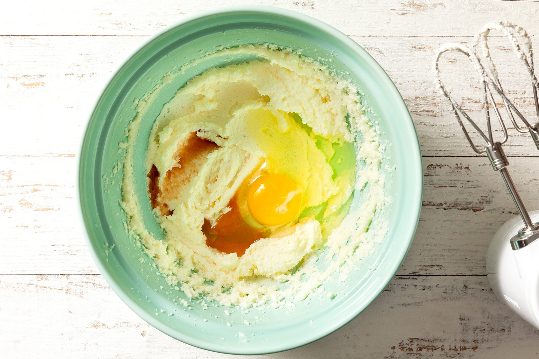 A bowl beaten eggs on a table 