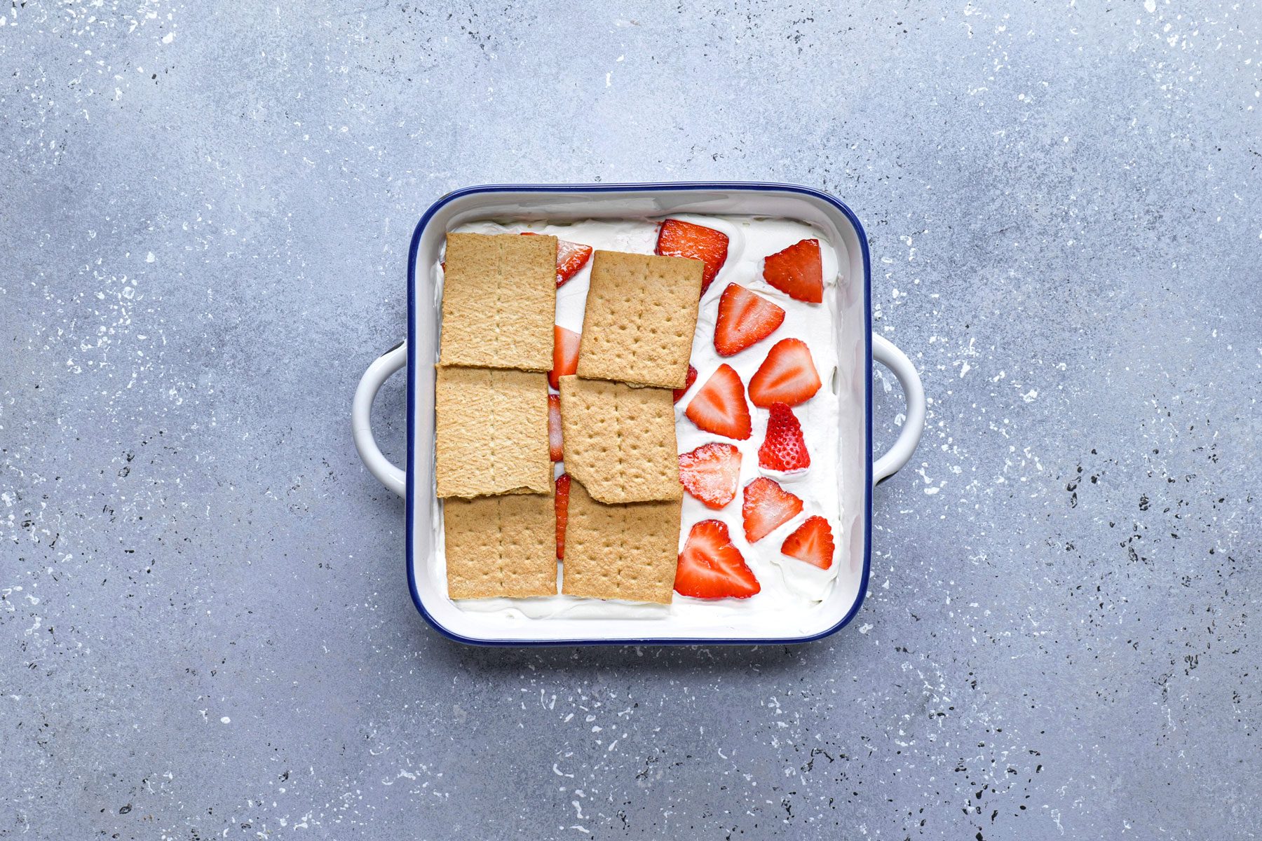 Crackers strawberries and cream mixture in a large pan