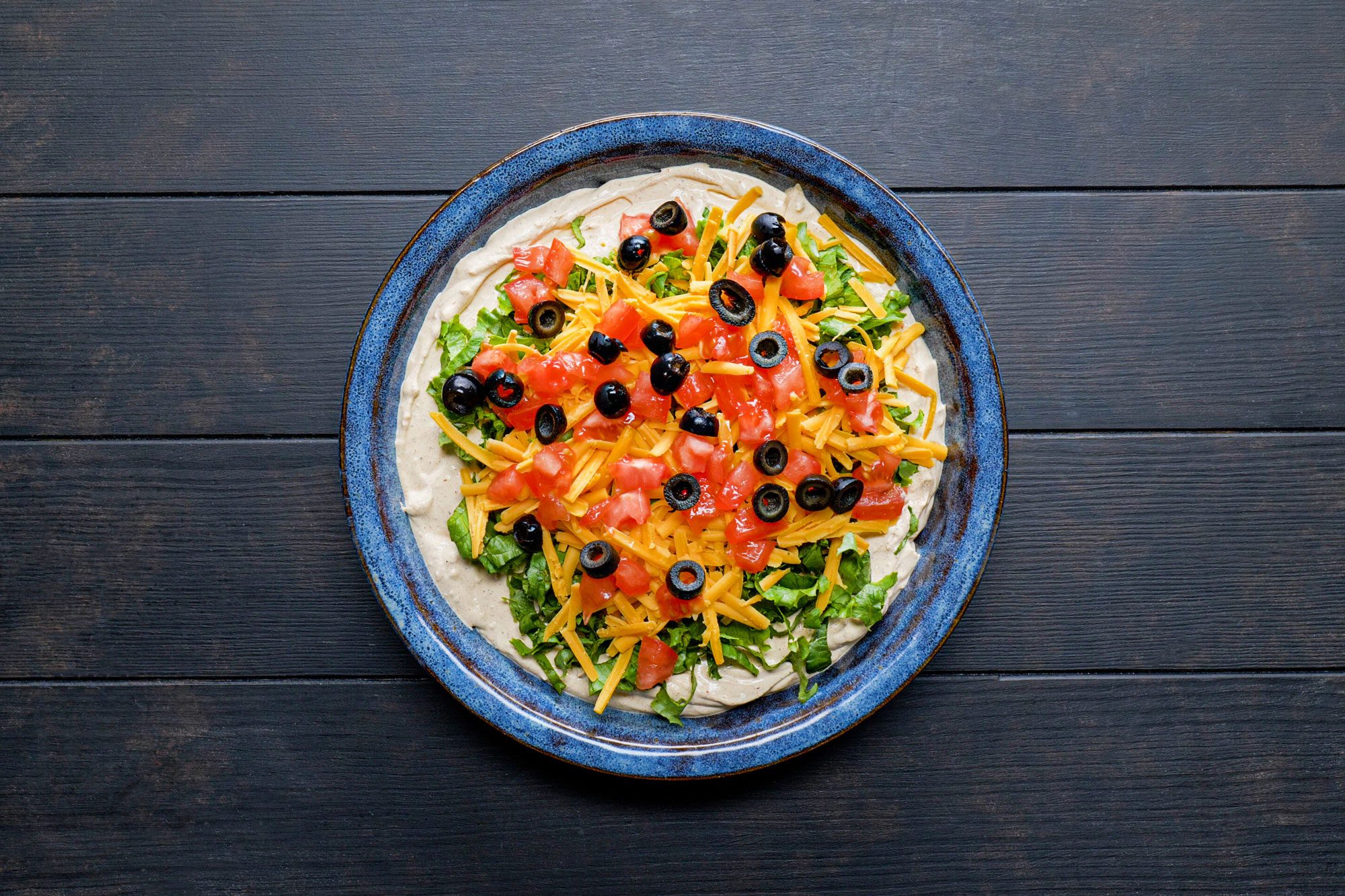 Taco Dip in a pie plate on wooden surface