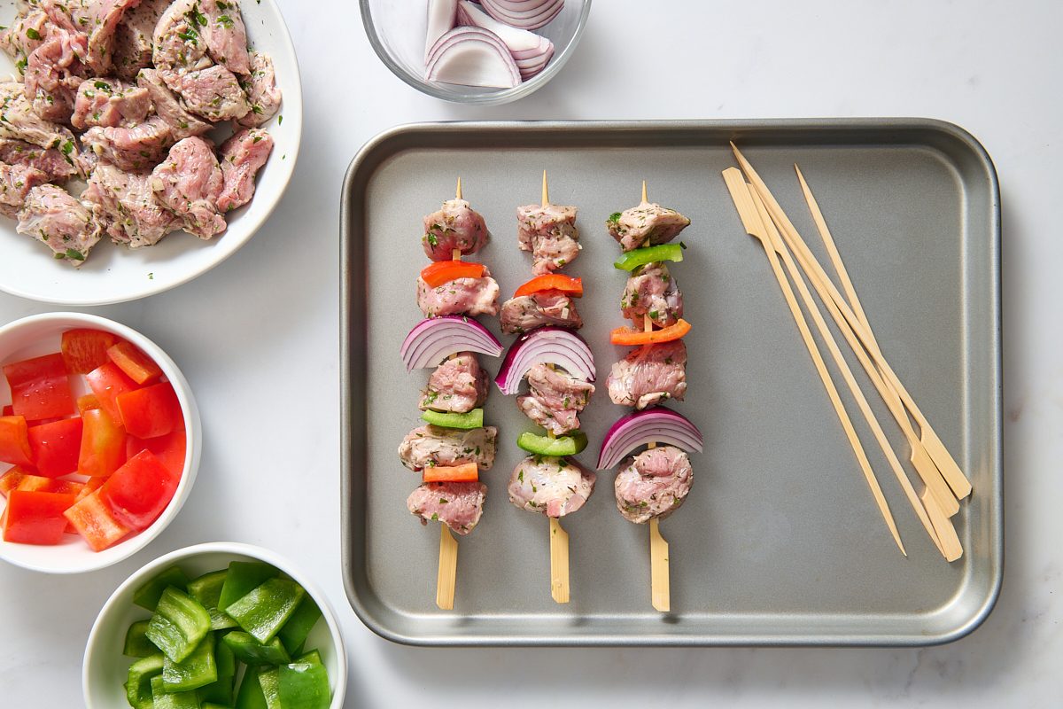 Assembling the meat and vegetables on skewers