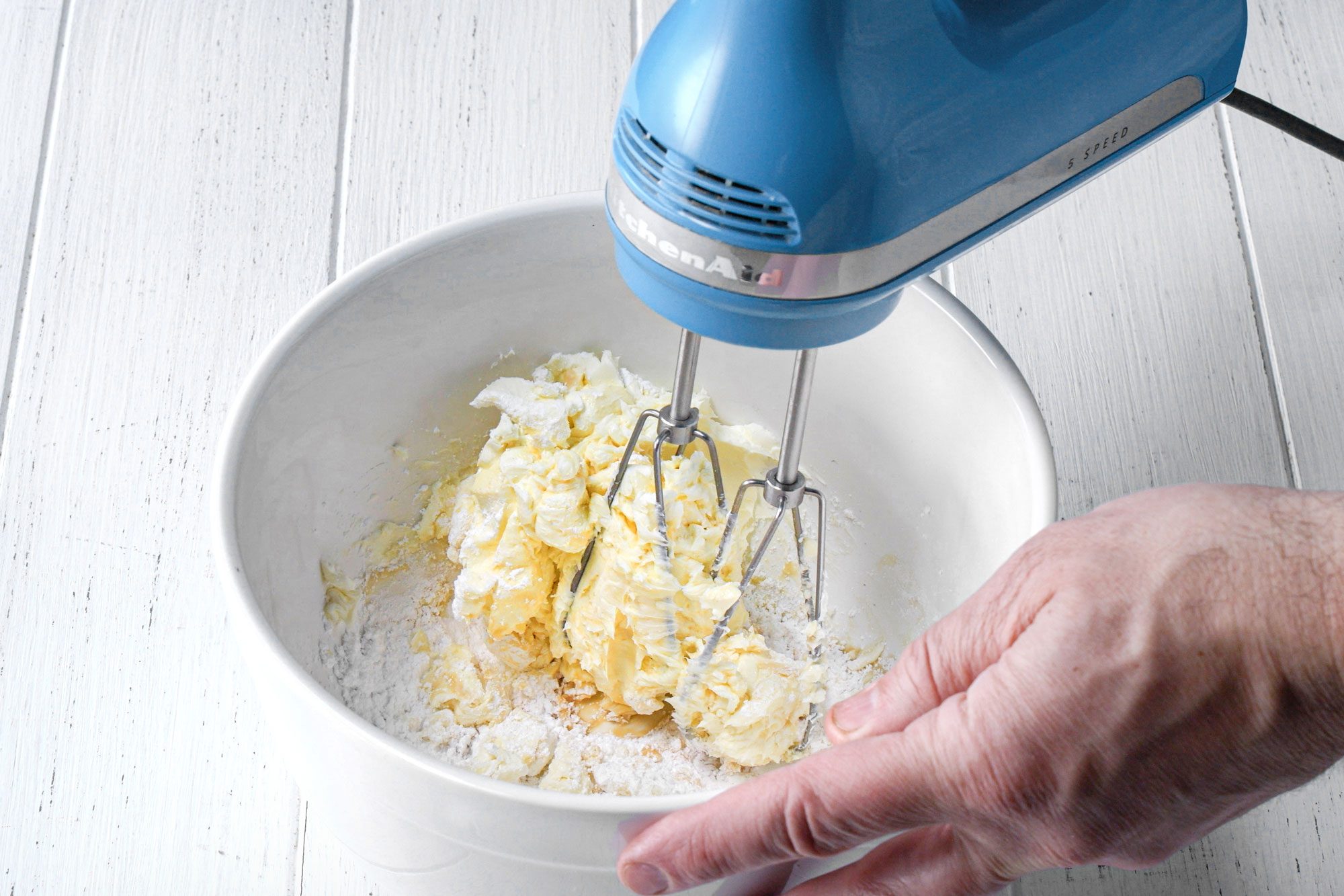 wide shot of blended cream cheese and sugar in a bowl