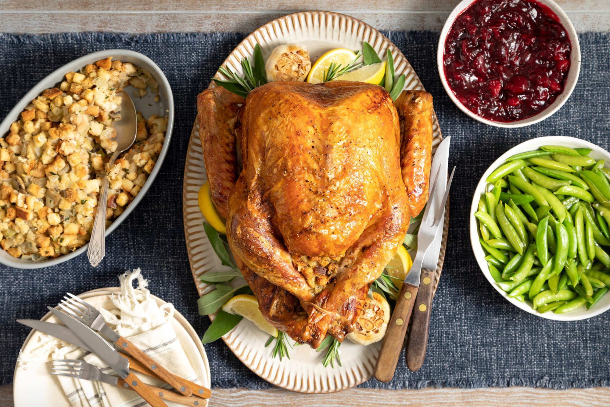 overhead shot of Stuffed Turkey Served on an oval shaped plate; kitchen napkin; wooden background;