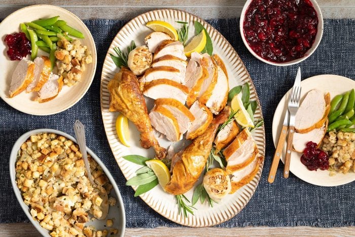 overhead shot of Stuffed Turkey Served on an oval shaped plate; kitchen napkin; wooden background;