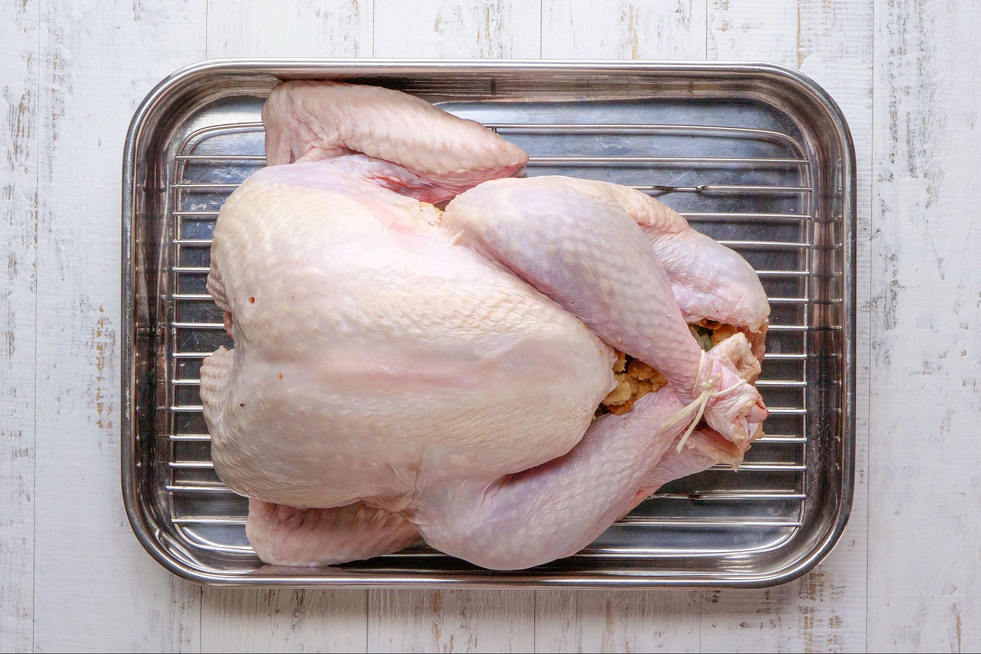 overhead shot of Stuffed Turkey placed in a roasting pan; wooden background;