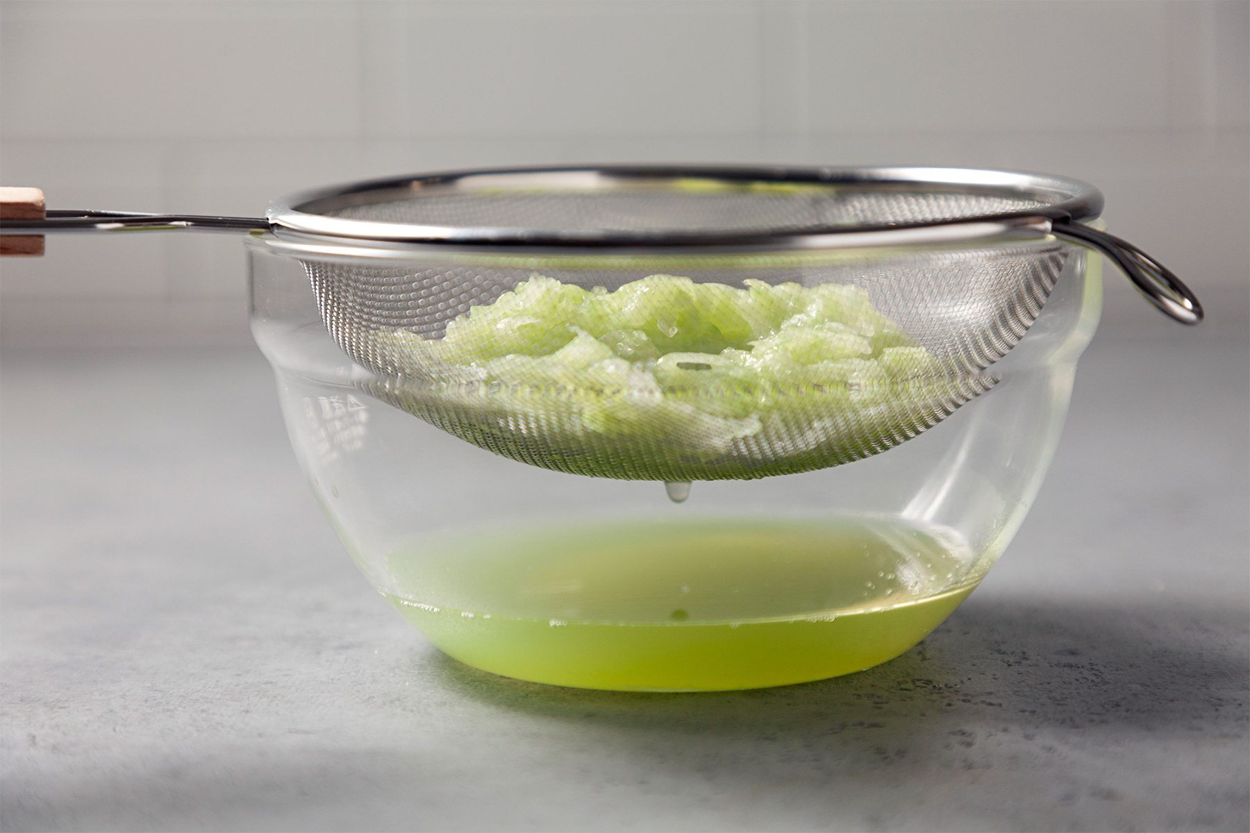 discarded liquid using strainer in glass bowl 