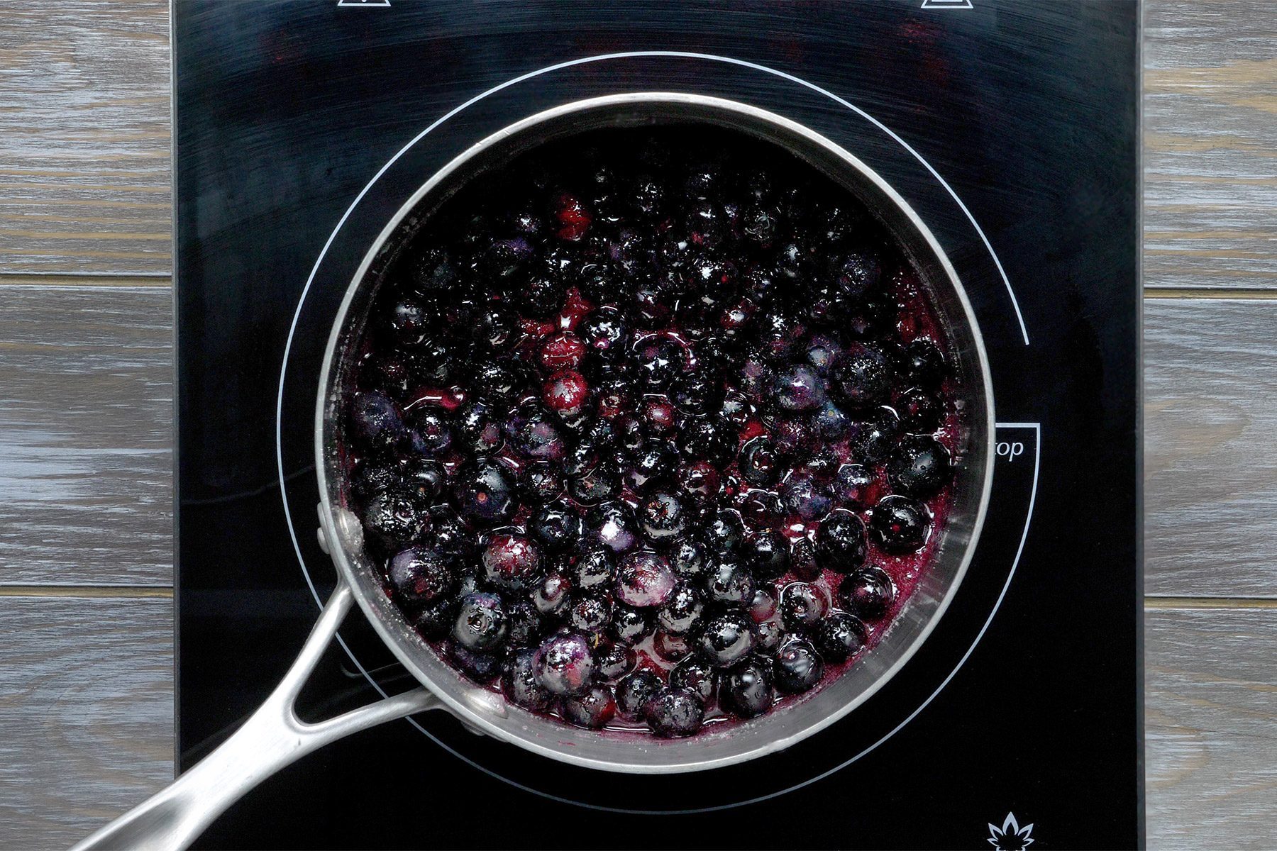 overhead shot; wooden background; In a saucepan, combine the berries;
