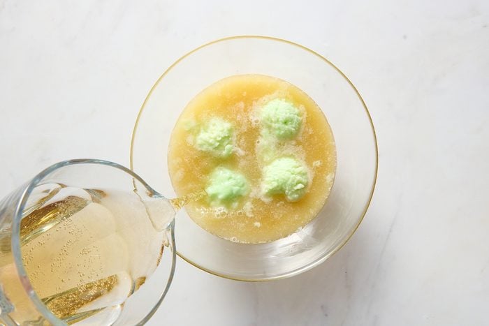Combining the lime sherbet punch ingredients in a large bowl