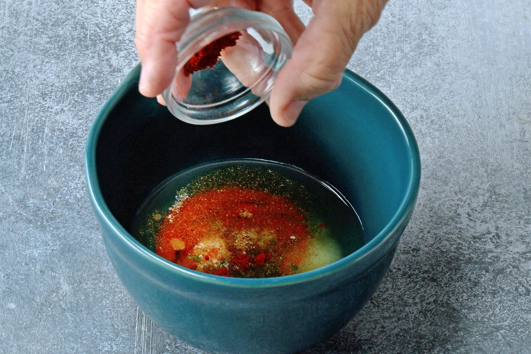 In a small bowl, whisk together the canola oil, Sriracha, lime juice, lime zest, salt, cumin and paprika until they're blended.
