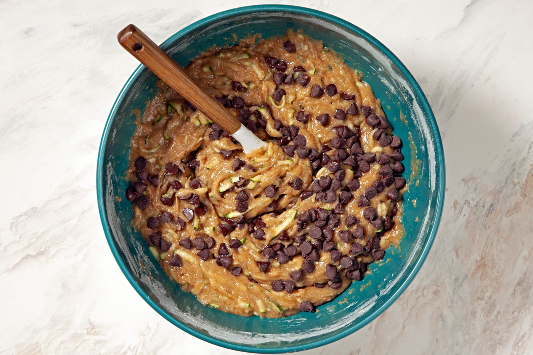 A bowl filled with a mixture of chocolate chips and nuts