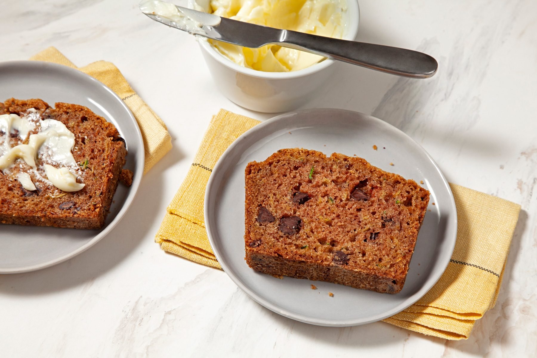 Two plates of Zucchini Chip Loaves on a marble counter