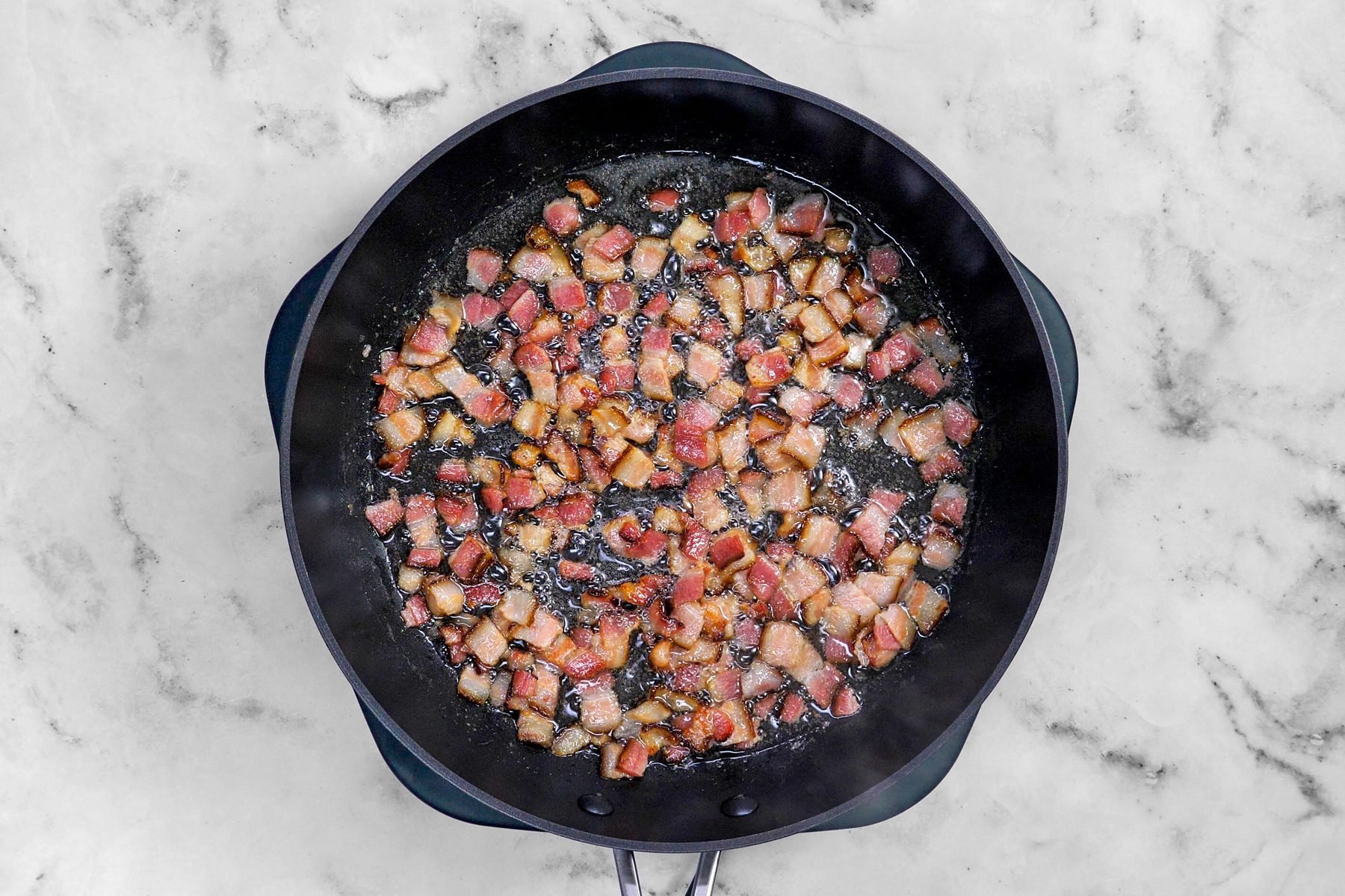 Top shot of bacon being fried in a skillet