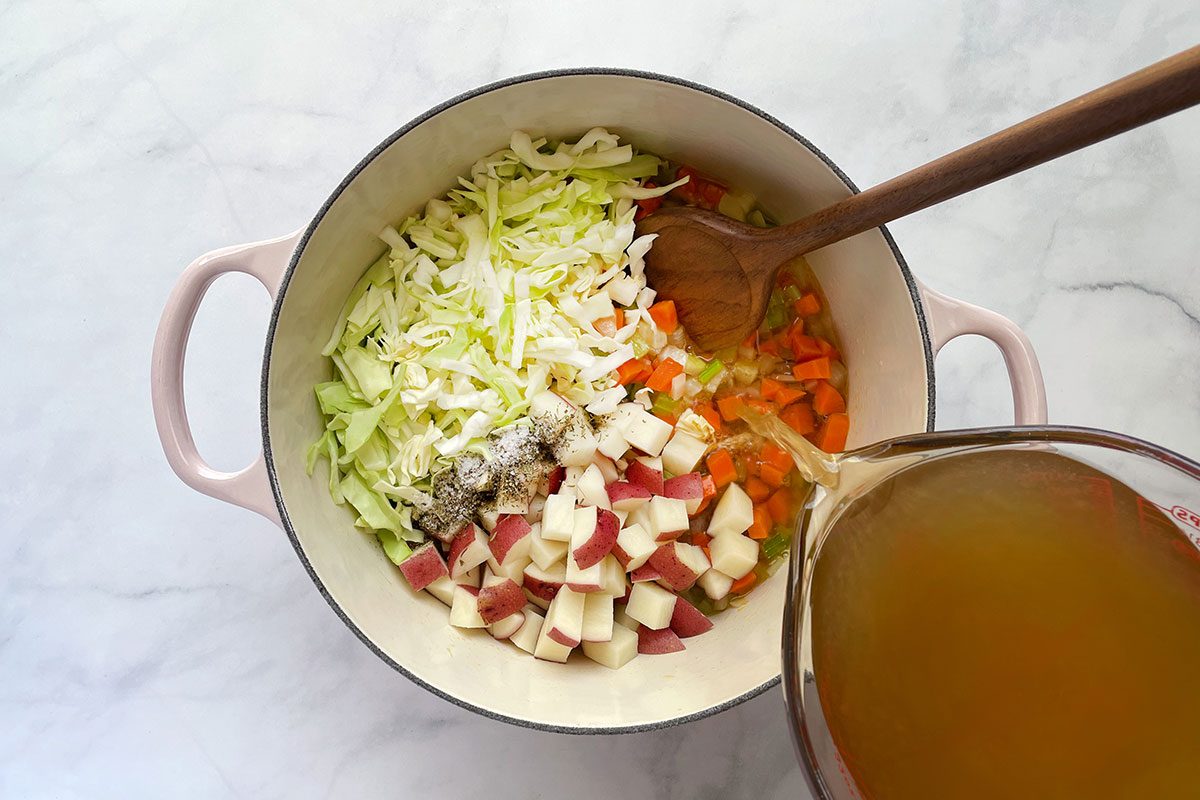 Step 2 for cooking Taste of Home's Chicken Cabbage Soup is adding broth, potatoes and cabbage