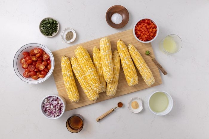 Ingredients For Corn Tomato Salad On Kitchen Counter.