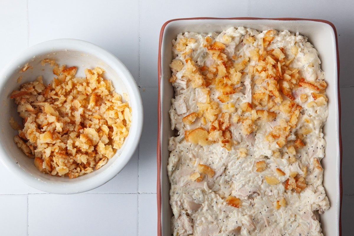 Step 2 of Taste of Home Poppy Seed Chicken is to add the chicken mixture to an 11x7 baking dish and top with buttered crackers mixed with melted butter