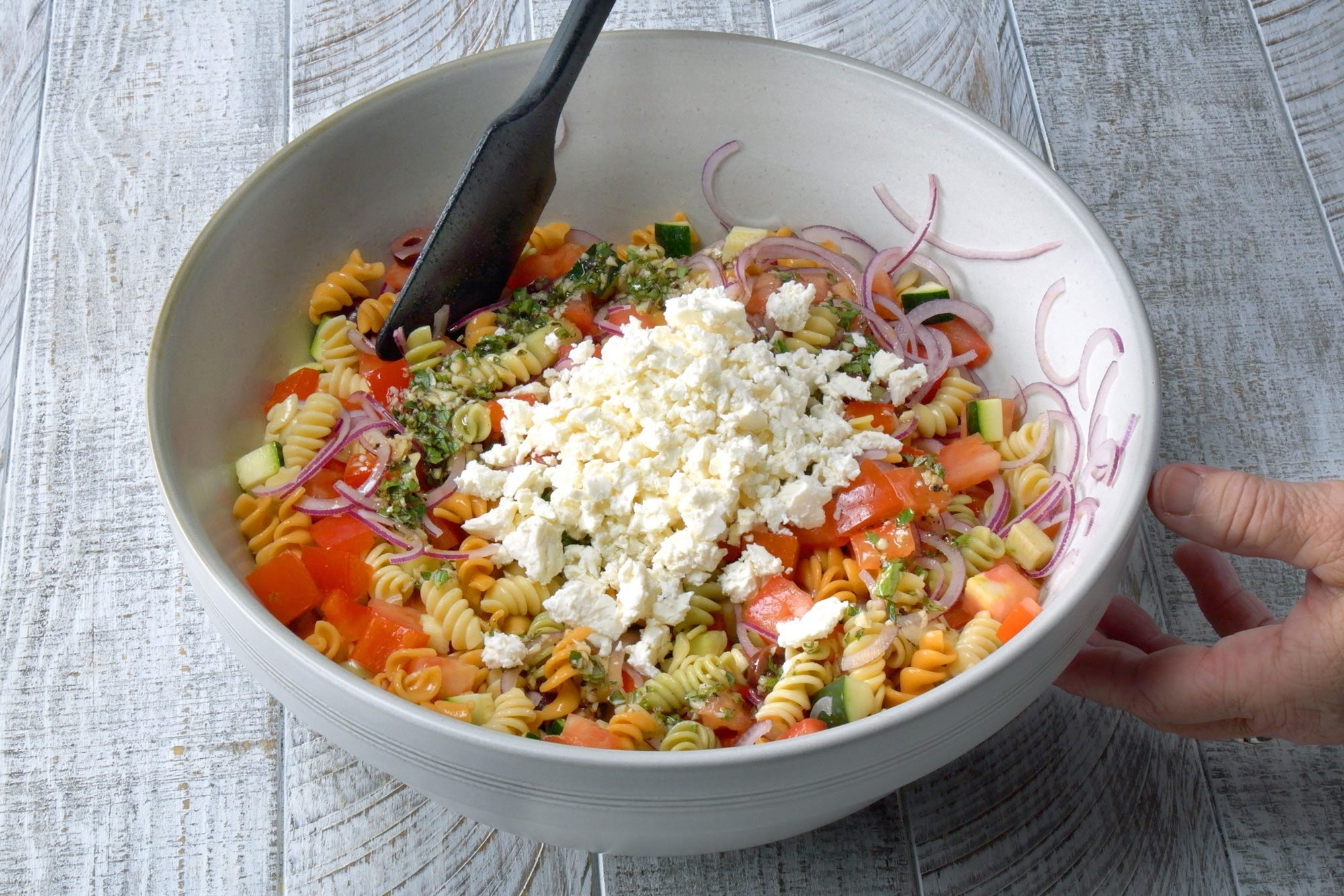 add grated cheese in the salad mix; wooden background;