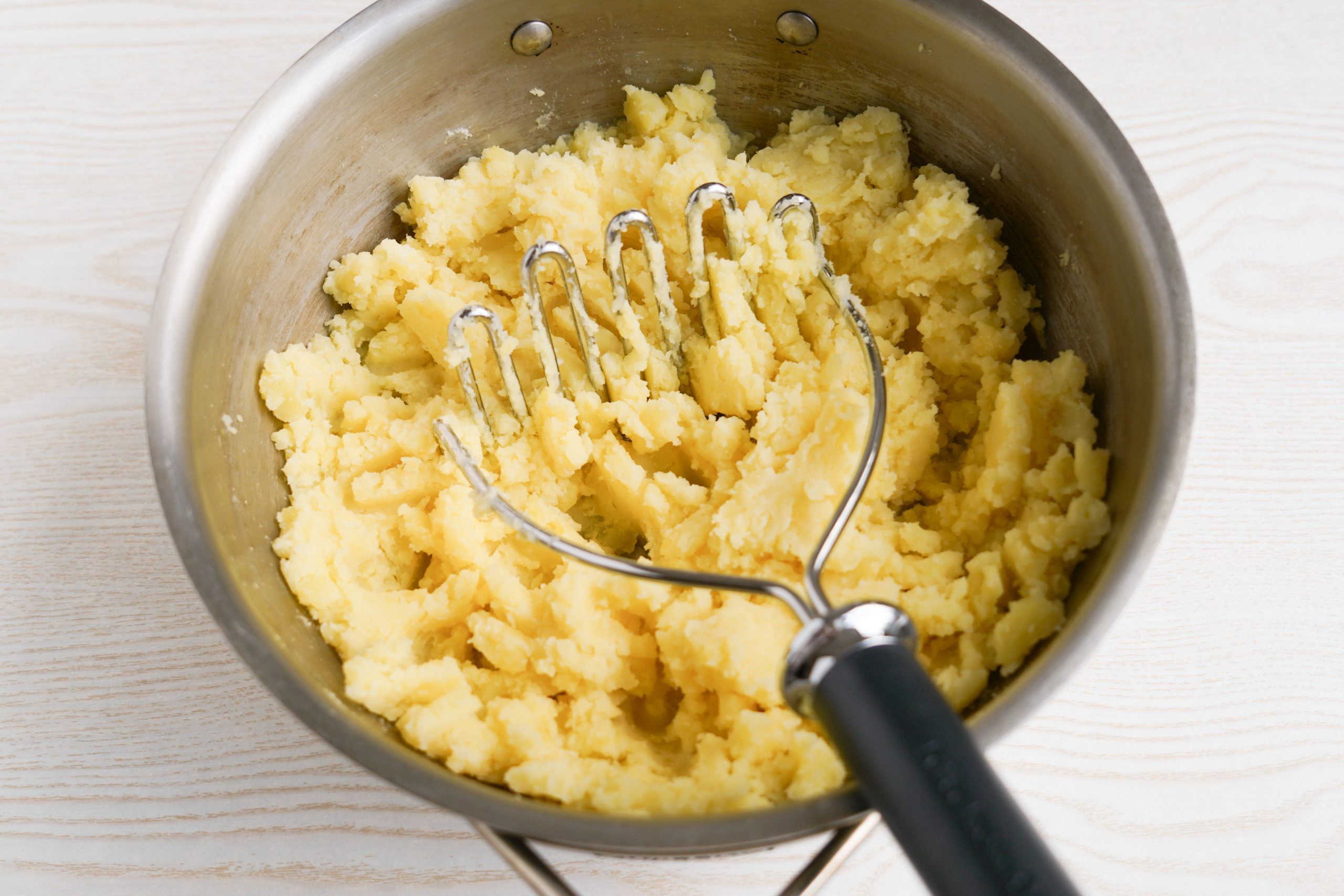 Mashing potatoes in a pot